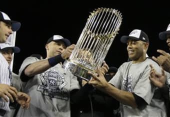 Derek Jeter of the New York Yankees holds up the trophy as he