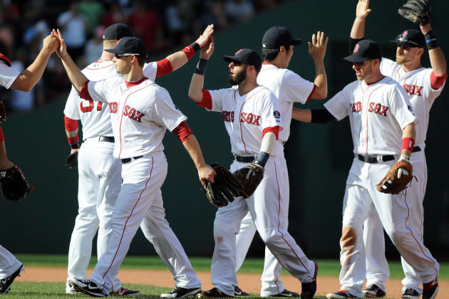 Former Boston Red Sox pitchers Curt Schilling, far right, and Keith Foulke,  holding the 2004 World Series trophy, and catcher Jason Varitek, far left,  applaud as 2004 teammate David Ortiz (34) joins