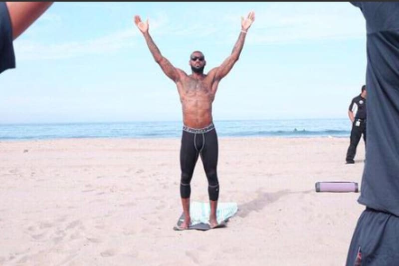 Lebron James practicing yoga on a brach