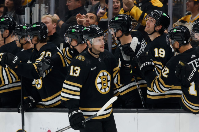 Boston Bruins center Charlie Coyle (13) celebrates his goal against the  Arizona Coyotes with defenseman Charlie McAvoy (73) and center Trent  Frederic, left, during the second period of an NHL hockey game