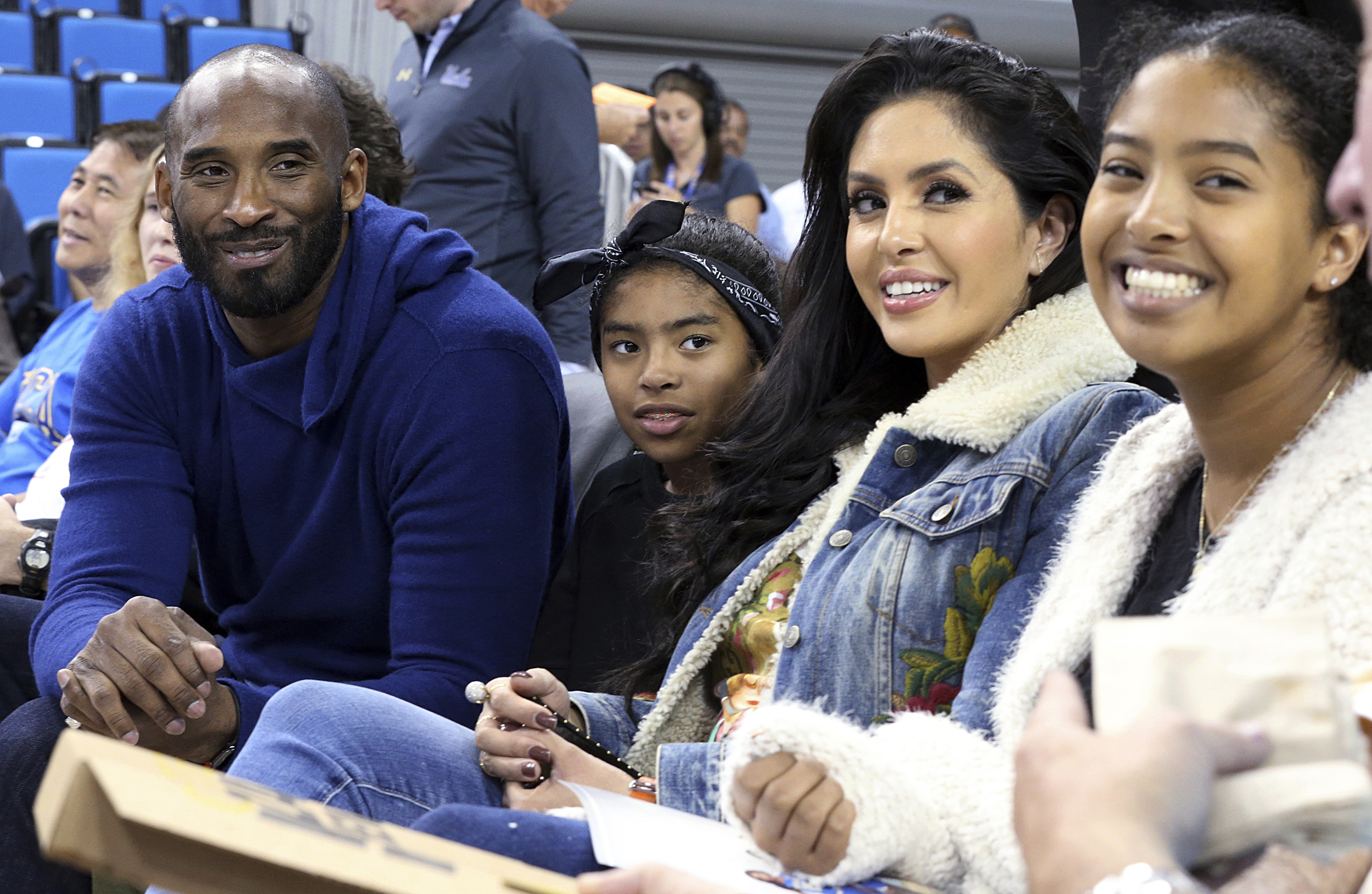FILE - In this Nov. 21, 2017 file photo, from left, Los Angeles Lakers legend Kobe Bryant, his daughter Gianna Maria-Onore Bryant, wife Vanessa and daughter Natalia Diamante Bryant are seen before a Connecticut-UCLA NCAA women's basketball game in Los Angeles. Kobe Bryant's widow on Monday, Feb. 24, 2020, sued the owner of the helicopter that crashed in fog and killed the former Los Angeles Lakers star and their 13-year-old daughter Gianna last month.  The wrongful death lawsuit filed by Vanessa Bryant in Los Angeles Superior Court said the pilot was careless and negligent by flying in cloudy conditions Jan. 26 and should have aborted the flight. (AP Photo/Reed Saxon, File)