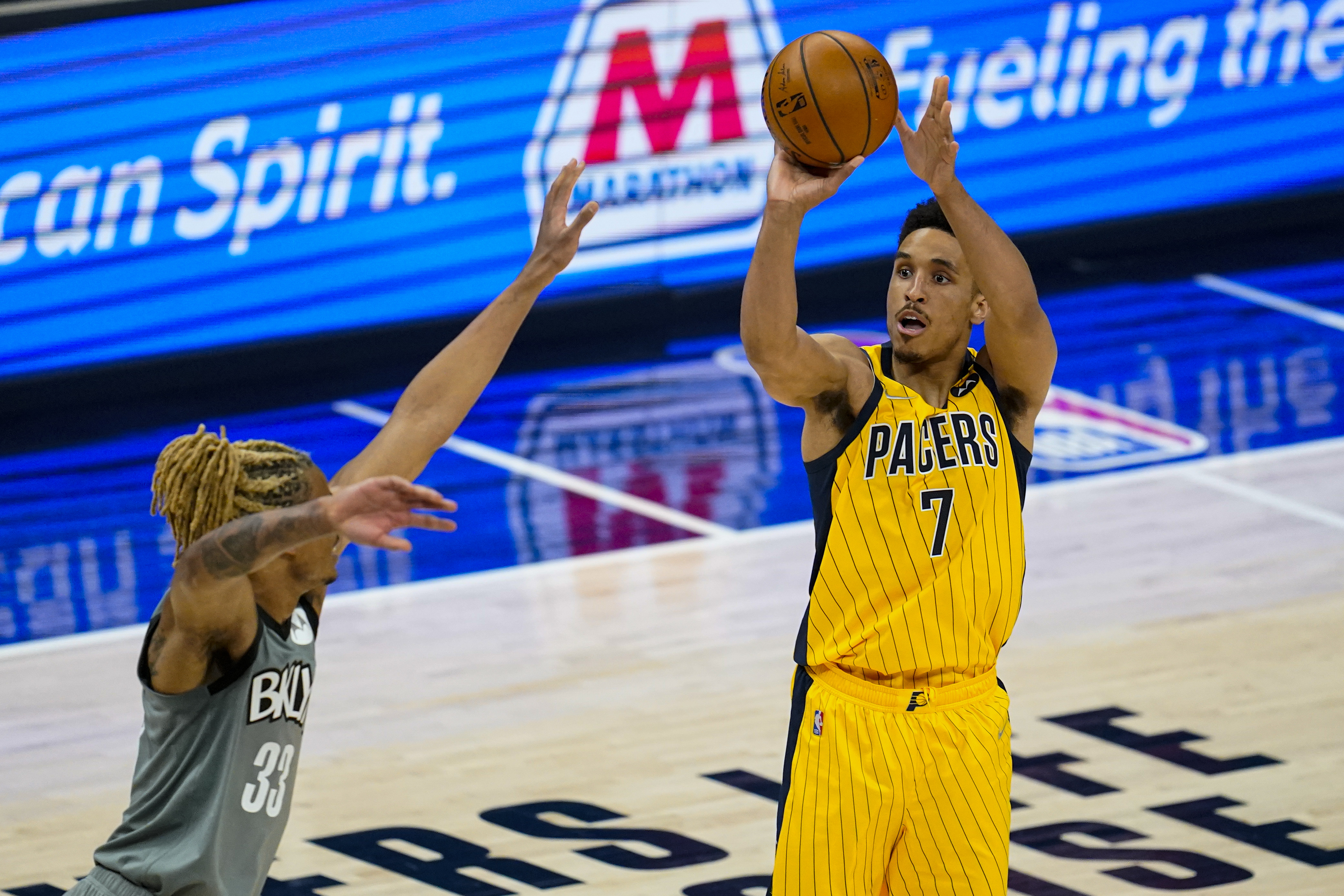 Indiana Pacers guard Malcolm Brogdon (7) shoots over Brooklyn Nets forward Nicolas Claxton (33) during the first half of an NBA basketball game in Indianapolis, Wednesday, March 17, 2021. (AP Photo/Michael Conroy)