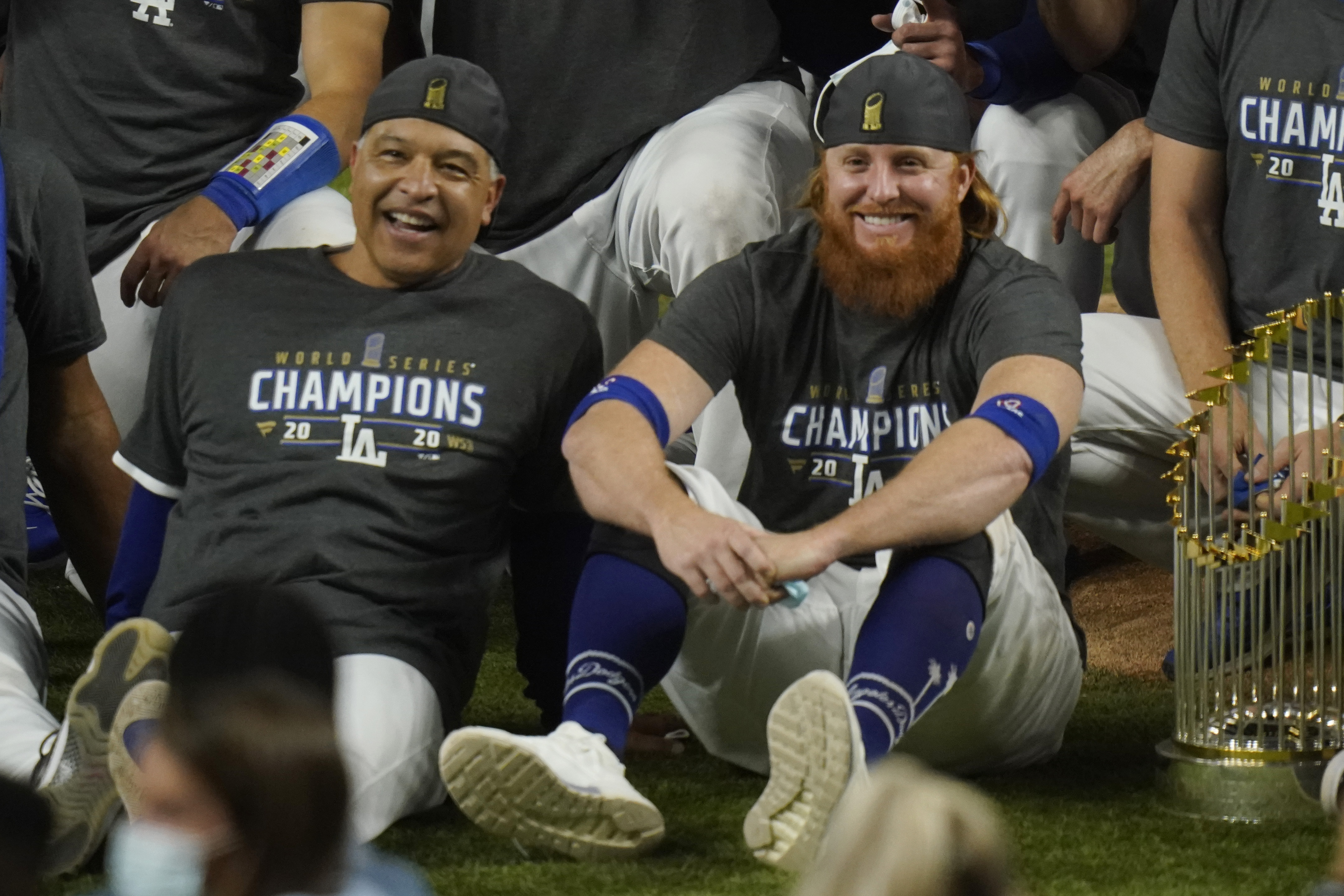 FILE - Los Angeles Dodgers manager Dave Roberts, left, and third baseman Justin Turner pose for a group picture after the Dodgers defeated the Tampa Bay Rays 3-1 in Game 6 to win the baseball World Series in Arlington, Texas, in this Tuesday, Oct. 27, 2020, file photo. Justin Turner's extended flirtation with free agency ended where it began â€” with the Los Angeles Dodgers. Along the way, the third baseman had doubts about whether he would return to his hometown team and wondered if his mask-less appearance on the field to celebrate its World Series championship would hurt him. (AP Photo/Eric Gay, File)