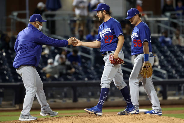 PEORIA, ARIZONA - MARCH 22: Trevor Bauer #27 hands the game ball over to to manager Dave Roberts #30 of the Los Angeles Dodgers after giving up five runs in the fifth inning against the Seattle Mariners during the MLB spring training game at Peoria Sports Complex on March 22, 2021 in Peoria, Arizona. (Photo by Abbie Parr/Getty Images)