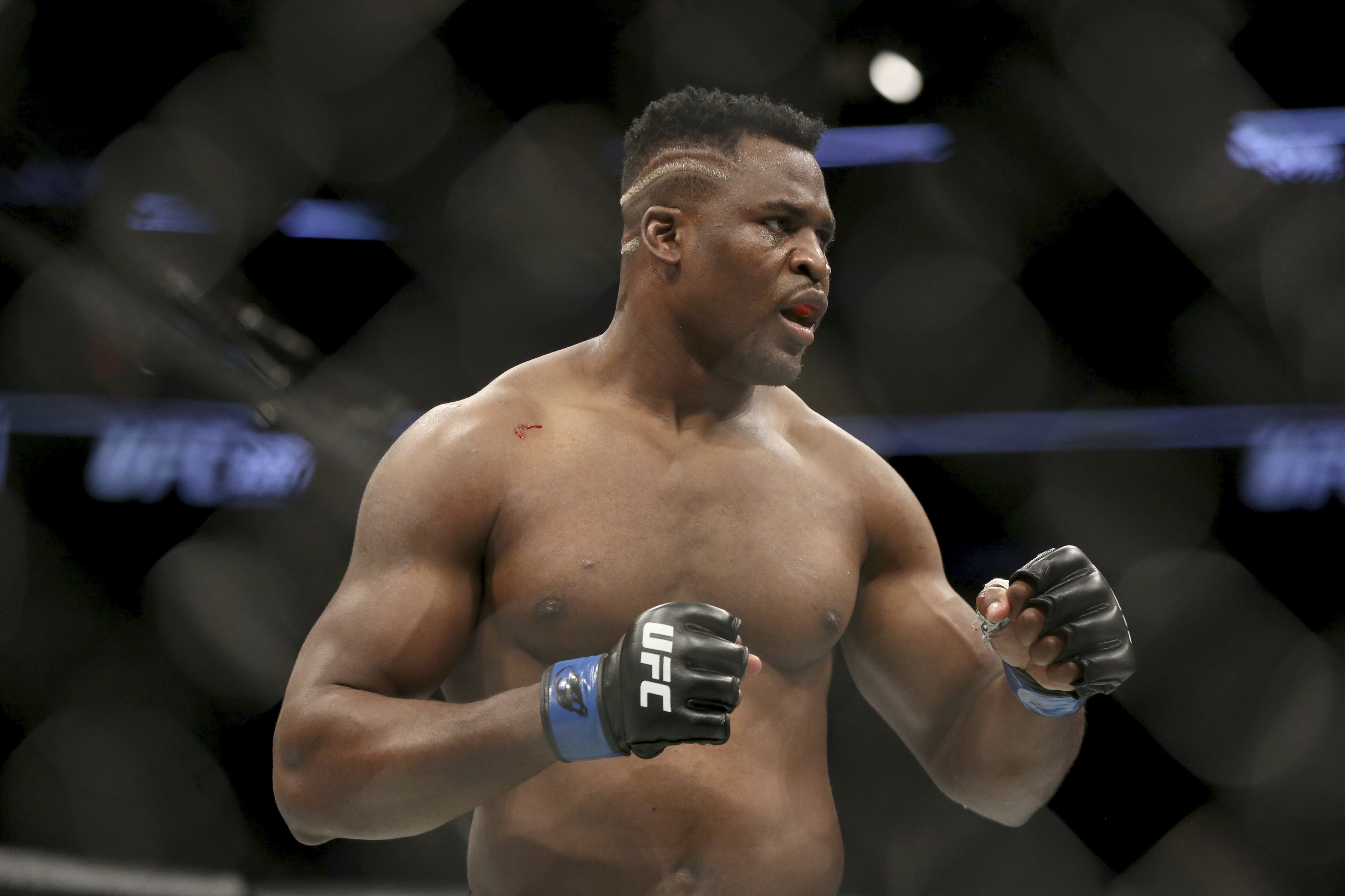 Francis Ngannou in action against Stipe Miocic during a heavyweight championship mixed martial arts bout at UFC 220, Sunday, Jan. 21, 2018, in Boston. Miocic retained his title via unanimous decision. (AP Photo/Gregory Payan)