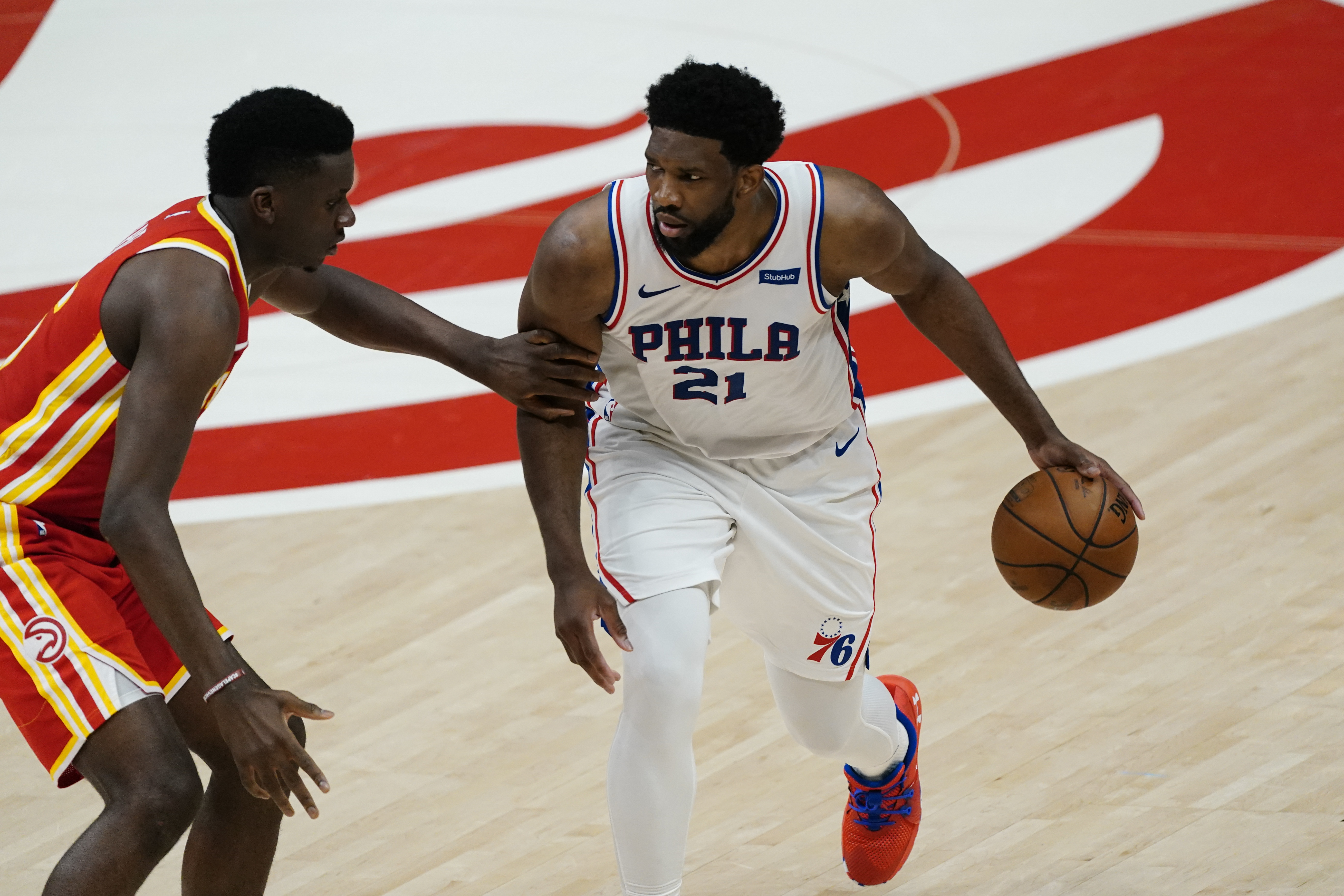 Philadelphia 76ers center Joel Embiid (21) is defended by Atlanta Hawks center Clint Capela (15) during the first half of Game 3 of a second-round NBA basketball playoff series, Friday, June 11, 2021, in Atlanta. (AP Photo/John Bazemore)