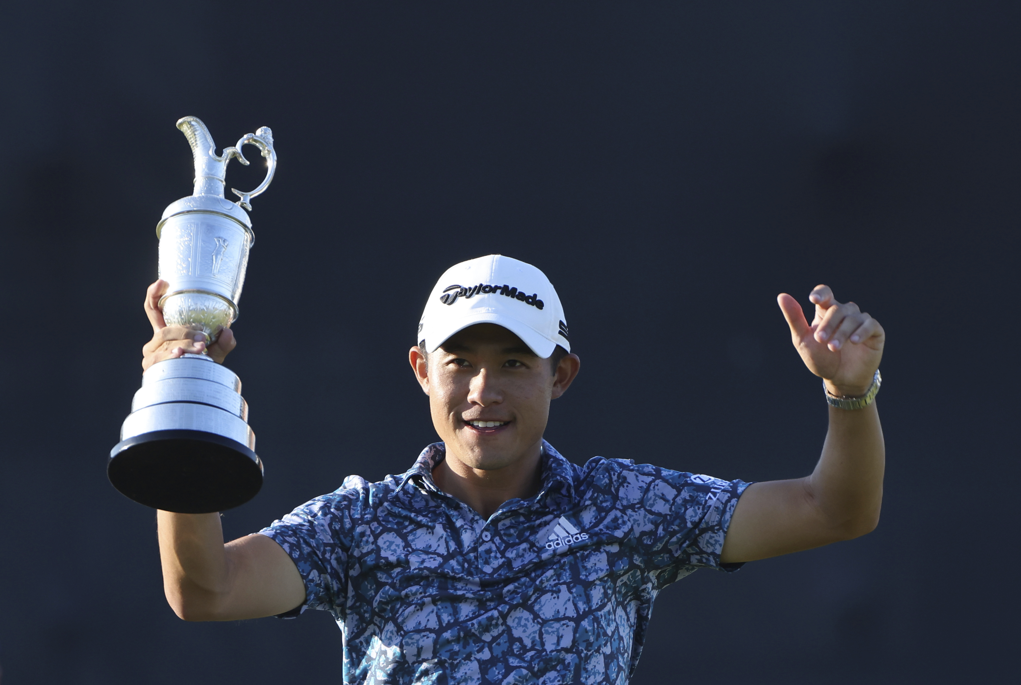United States' Collin Morikawa holds up the claret jug trophy as he poses for photographers on the 18th green after winning the British Open Golf Championship at Royal St George's golf course Sandwich, England, Sunday, July 18, 2021. (AP Photo/Ian Walton)
