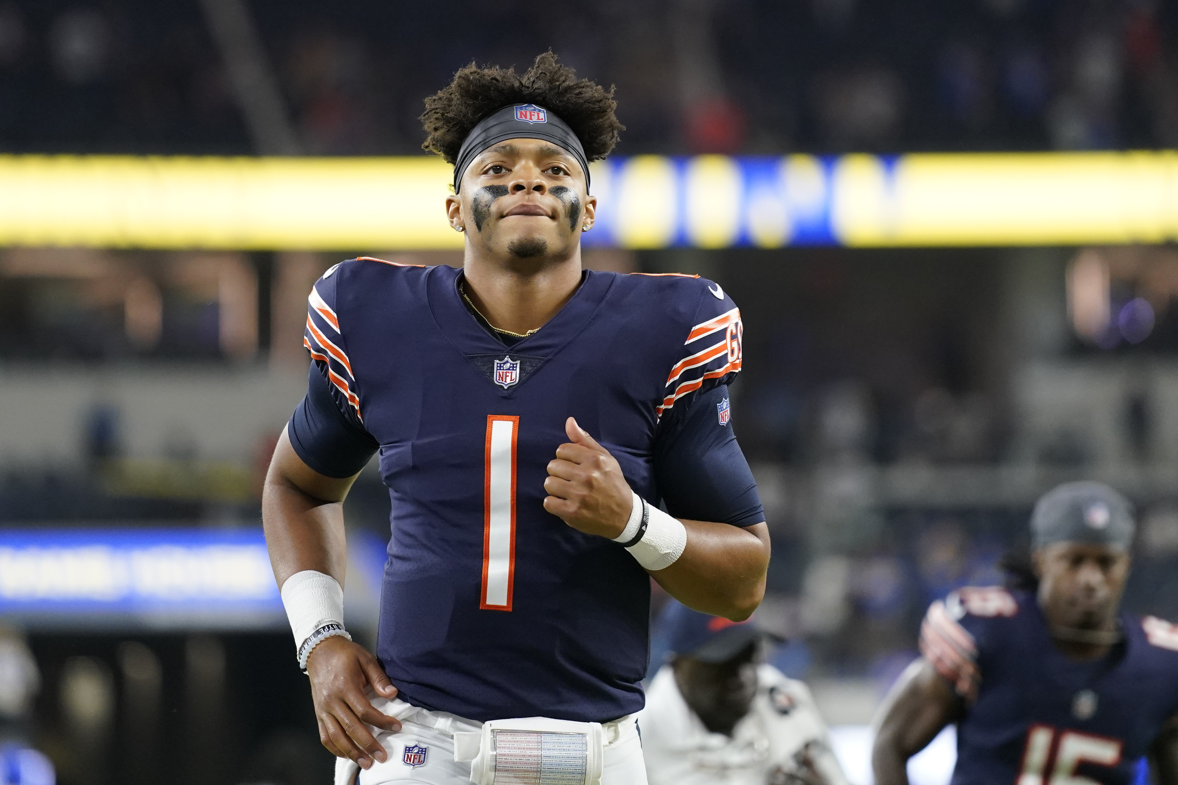 A Chicago Bears fan holds a quarterback Justin Fields jersey