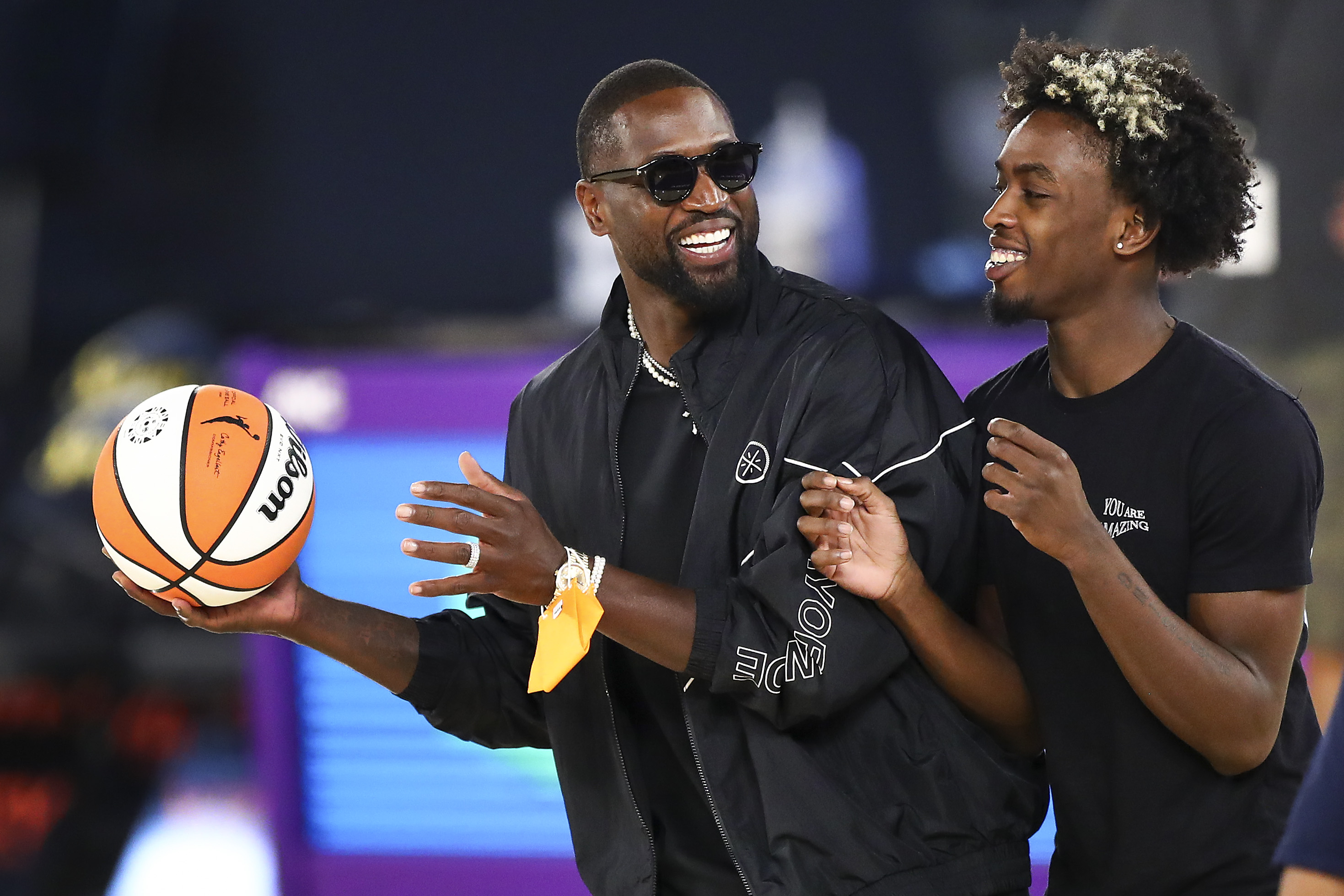 LOS ANGELES, CALIFORNIA - JUNE 30: Former NBA player Dwyane Wade and his son Zaire Wade spend time on the court after the game between the Los Angeles Sparks and the Las Vegas Aces at Los Angeles Convention Center on June 30, 2021 in Los Angeles, California. NOTE TO USER: User expressly acknowledges and agrees that, by downloading and or using this photograph, User is consenting to the terms and conditions of the Getty Images License Agreement. (Photo by Meg Oliphant/Getty Images)