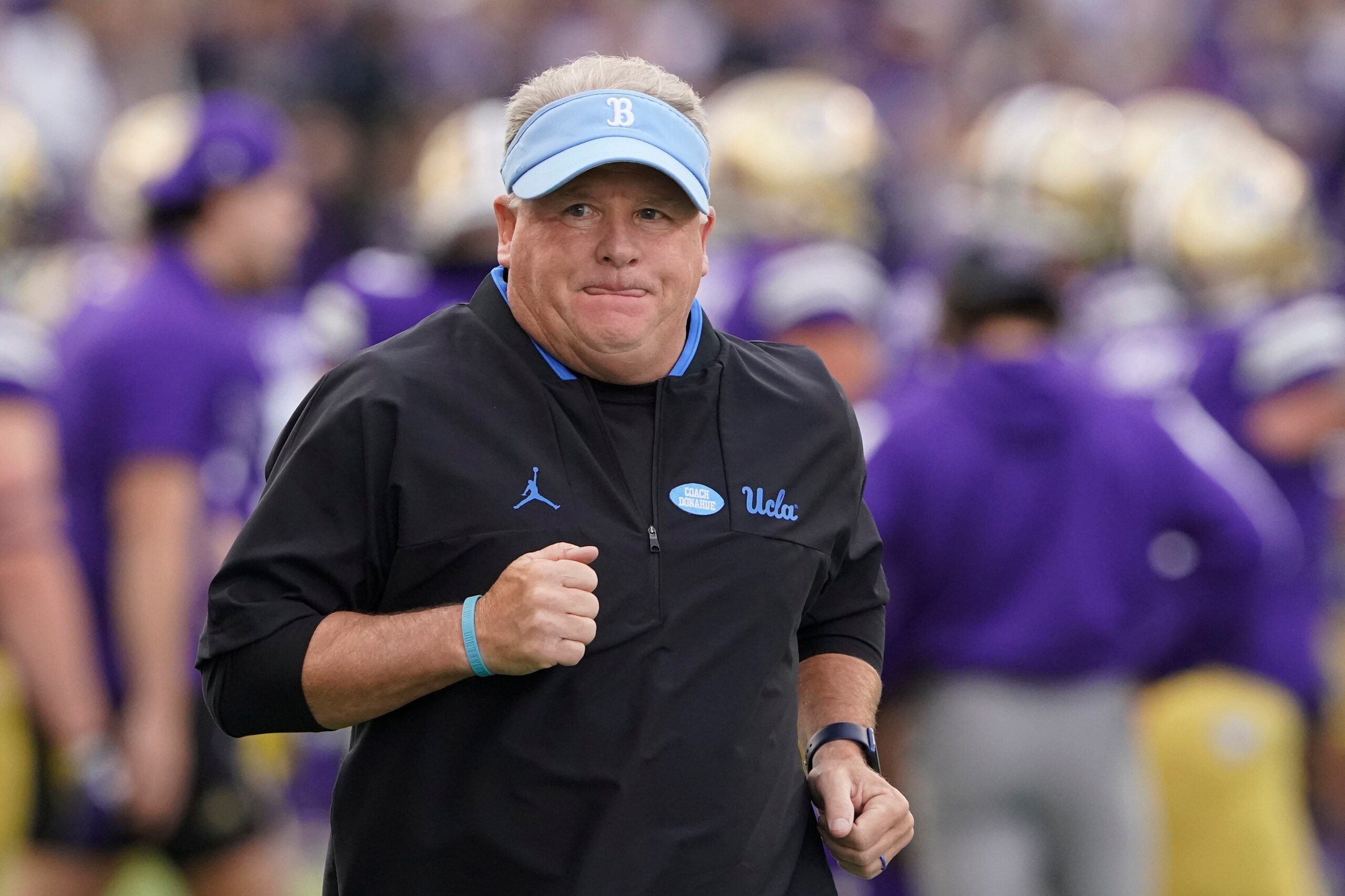 UCLA head coach Chip Kelly runs on the field before the team's NCAA college football game against Washington, Saturday, Oct. 16, 2021, in Seattle. (AP Photo/Ted S. Warren)