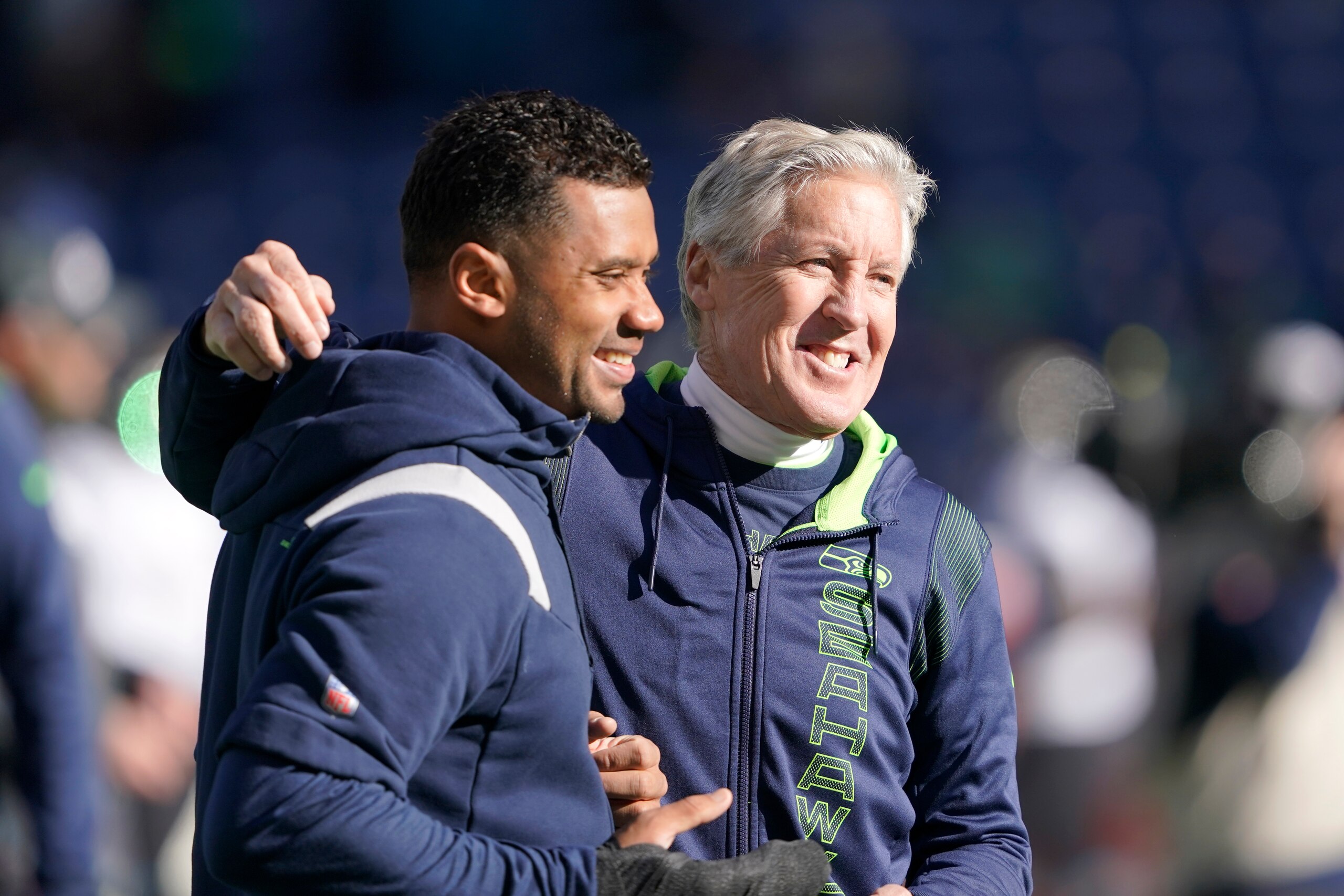 Seattle Seahawks head coach Pete Carroll, right, throws his arm around injured quarterback Russell Wilson as they walk on the field before an NFL football game against the Jacksonville Jaguars, Sunday, Oct. 31, 2021, in Seattle. (AP Photo/Ted S. Warren)