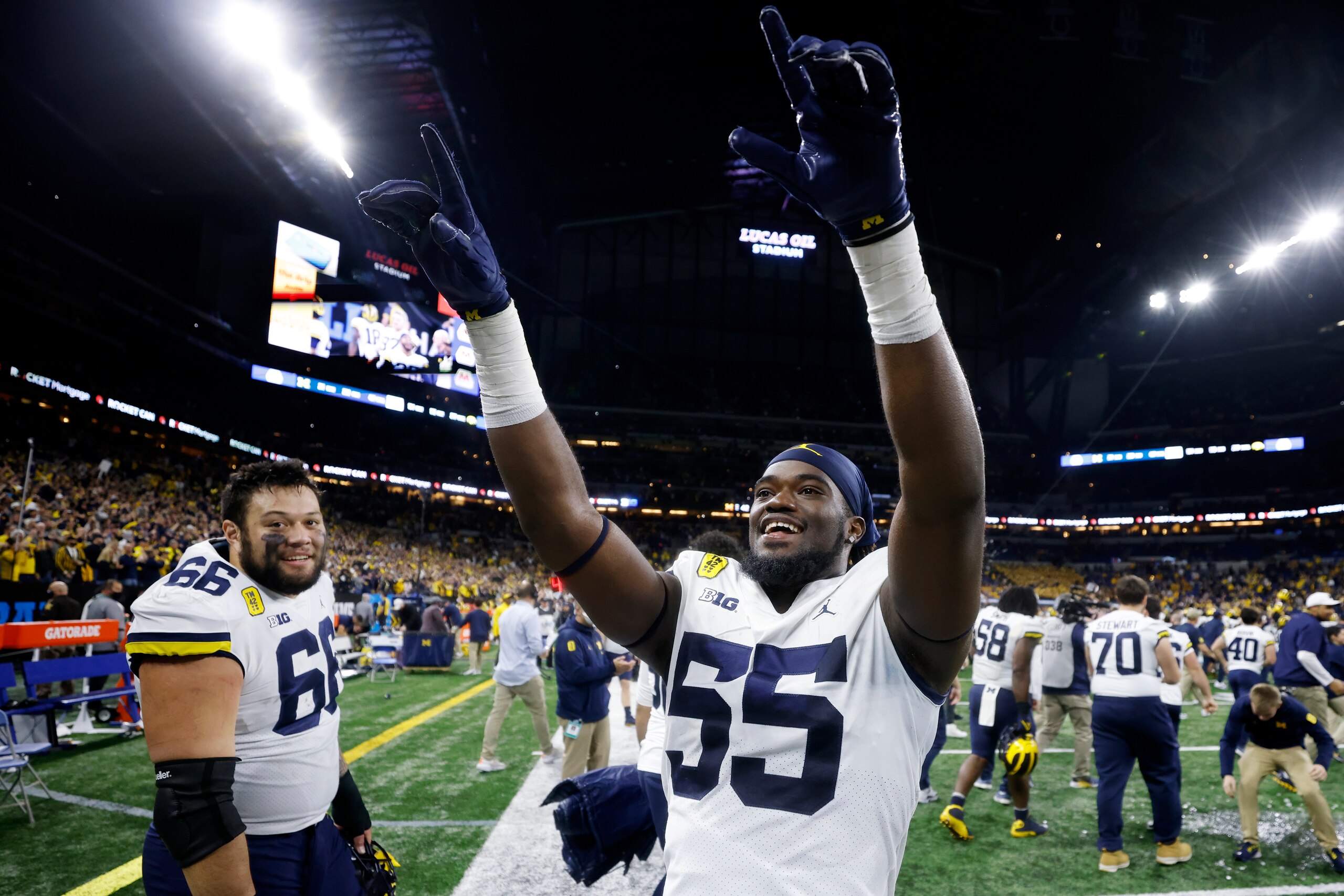 INDIANAPOLIS, IN - DECEMBER 04: Michigan Wolverines linebacker David Ojabo (55) and offensive lineman Chuck Filiaga (66) celebrate after a win in the Big Ten Championship college football game against the Iowa Hawkeyes on Dec. 4, 2021 at Lucas Oil Stadium in Indianapolis, Indiana. (Photo by Joe Robbins/Icon Sportswire via Getty Images)