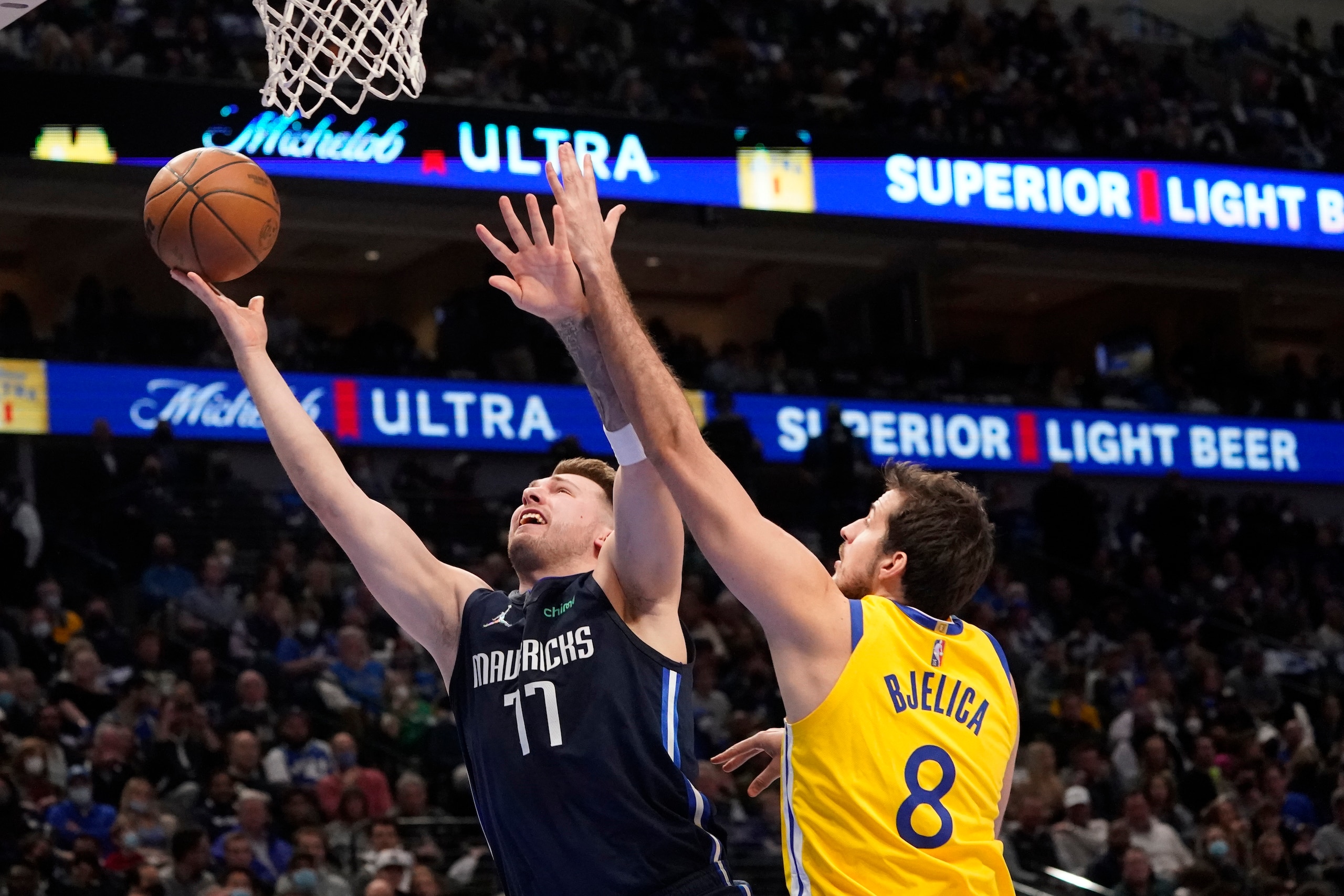 Dallas Mavericks guard Luka Doncic (77) shoots against Golden State Warriors forward Nemanja Bjelica (8) during the first quarter of an NBA basketball game in Dallas, Wednesday, Jan. 5, 2022. (AP Photo/LM Otero)