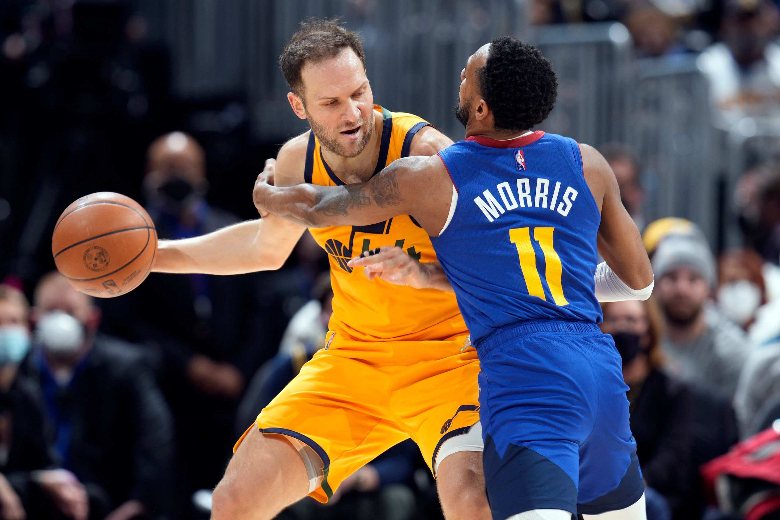 Utah Jazz forward Bojan Bogdanovic, left, looks to pass the ball as Denver Nuggets guard Monte Morris defends in the first half of an NBA basketball game Wednesday, Jan. 5, 2022, in Denver. (AP Photo/David Zalubowski)