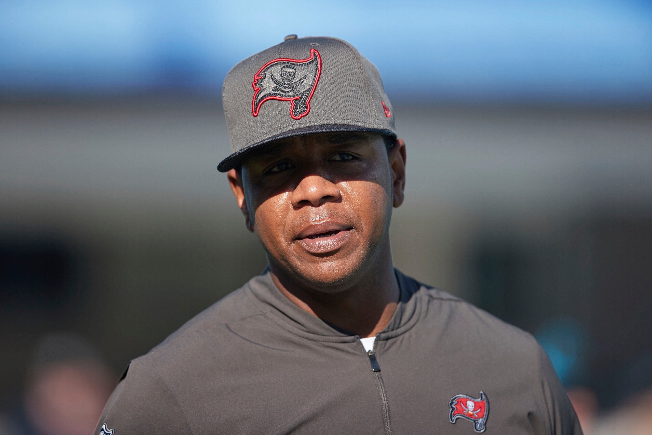 Tampa Bay Buccaneers offensive coordinator Byron Leftwich smiles prior to an NFL football game against the Carolina Panthers, Sunday, Dec. 26, 2021, in Charlotte, N.C. (AP Photo/Brian Westerholt)