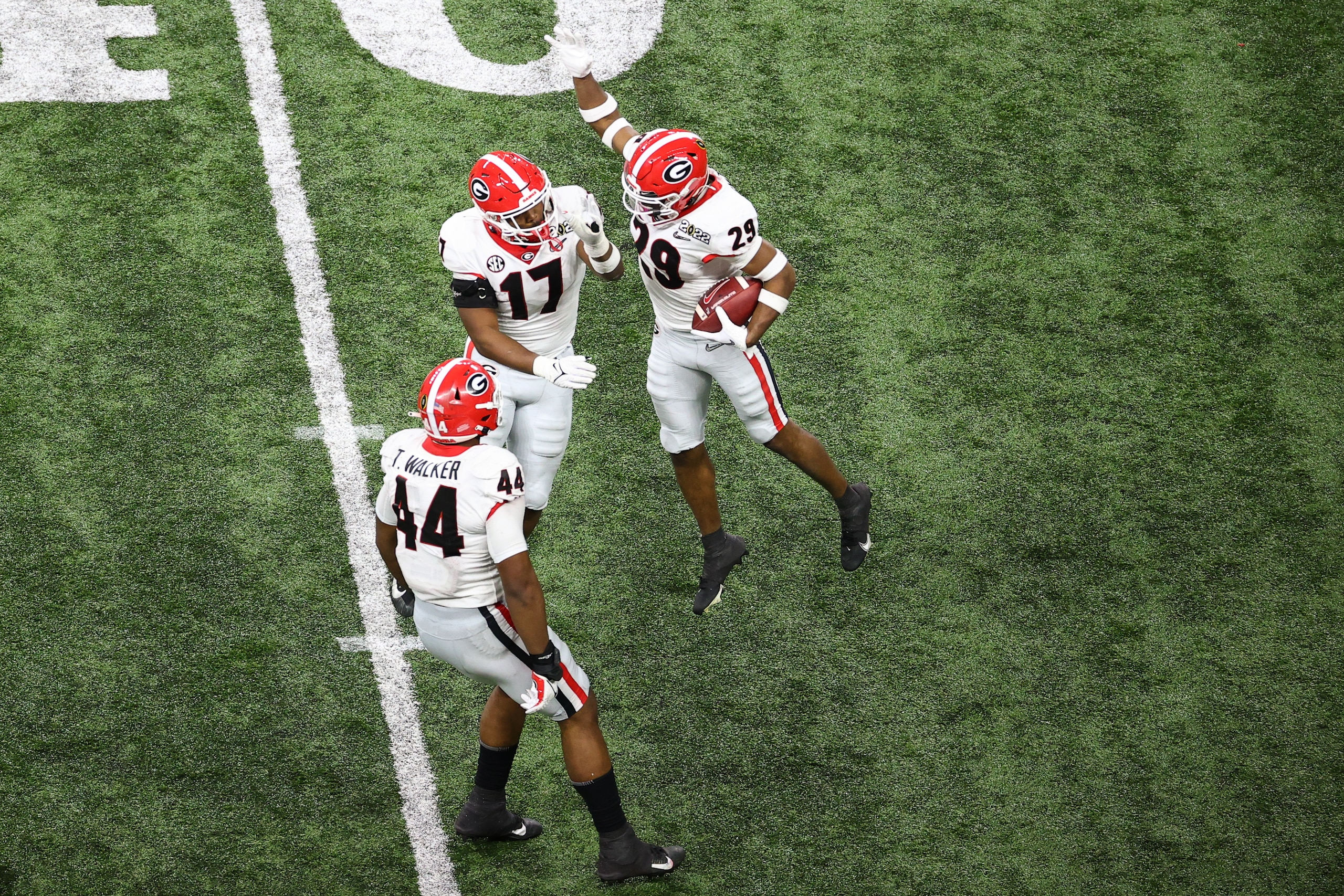 INDIANAPOLIS, IN - JANUARY 10: Christopher Smith #29 and Nakobe Dean #17 of the Georgia Bulldogs celebrate an interception against the Alabama Crimson Tide during the College Football Playoff Championship held at Lucas Oil Stadium on January 10, 2022 in Indianapolis, Indiana. (Photo by Jamie Schwaberow/Getty Images)