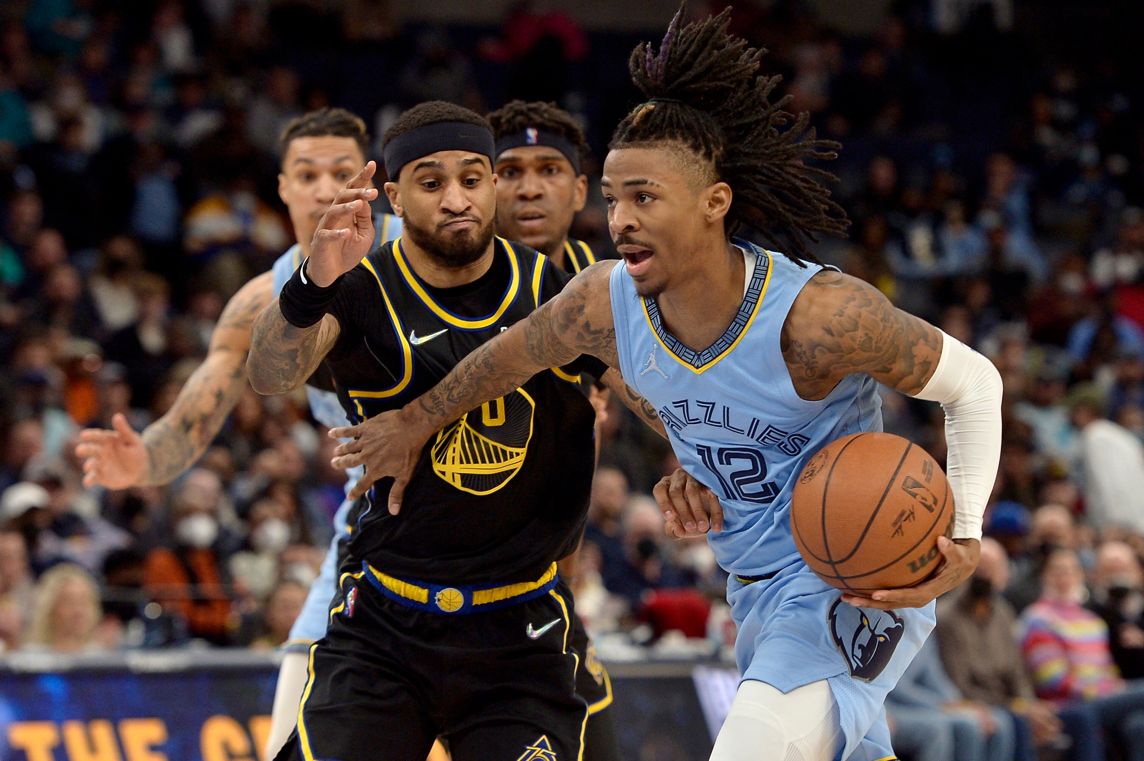 Memphis Grizzlies guard Ja Morant (12) handles the ball against Golden State Warriors guard Gary Payton II (0) in the second half of an NBA basketball game Tuesday, Jan. 11, 2022, in Memphis, Tenn. (AP Photo/Brandon Dill)