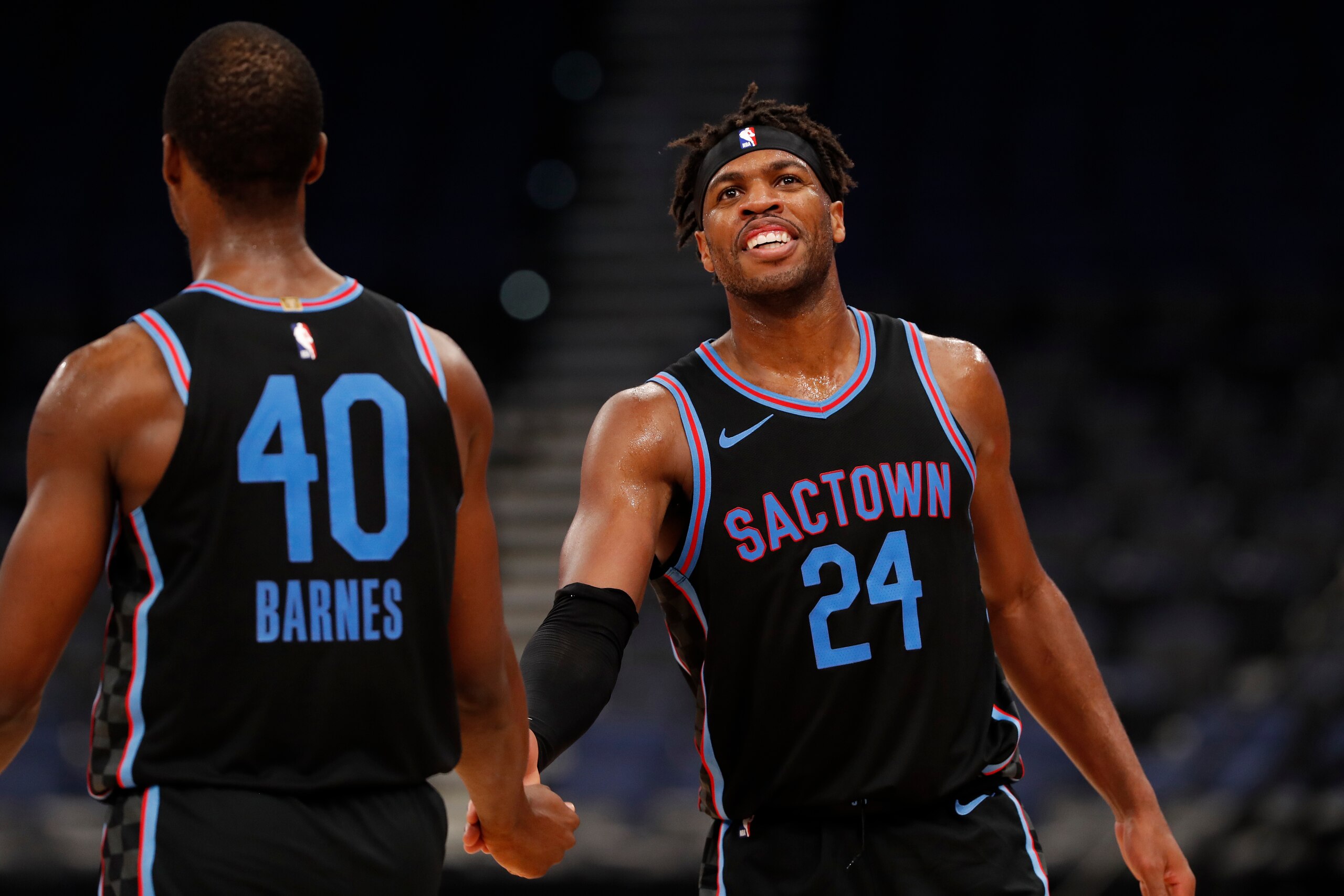 TAMPA, FL - JANUARY 29: Buddy Hield #24 and Harrison Barnes #40 of the Sacramento Kings smile and shake hands against the Toronto Raptors on January 29, 2021 at Amalie Arena in Tampa, Florida. NOTE TO USER: User expressly acknowledges and agrees that, by downloading and or using this Photograph, user is consenting to the terms and conditions of the Getty Images License Agreement. Mandatory Copyright Notice: Copyright 2021 NBAE (Photo by Scott Audette/NBAE via Getty Images)
