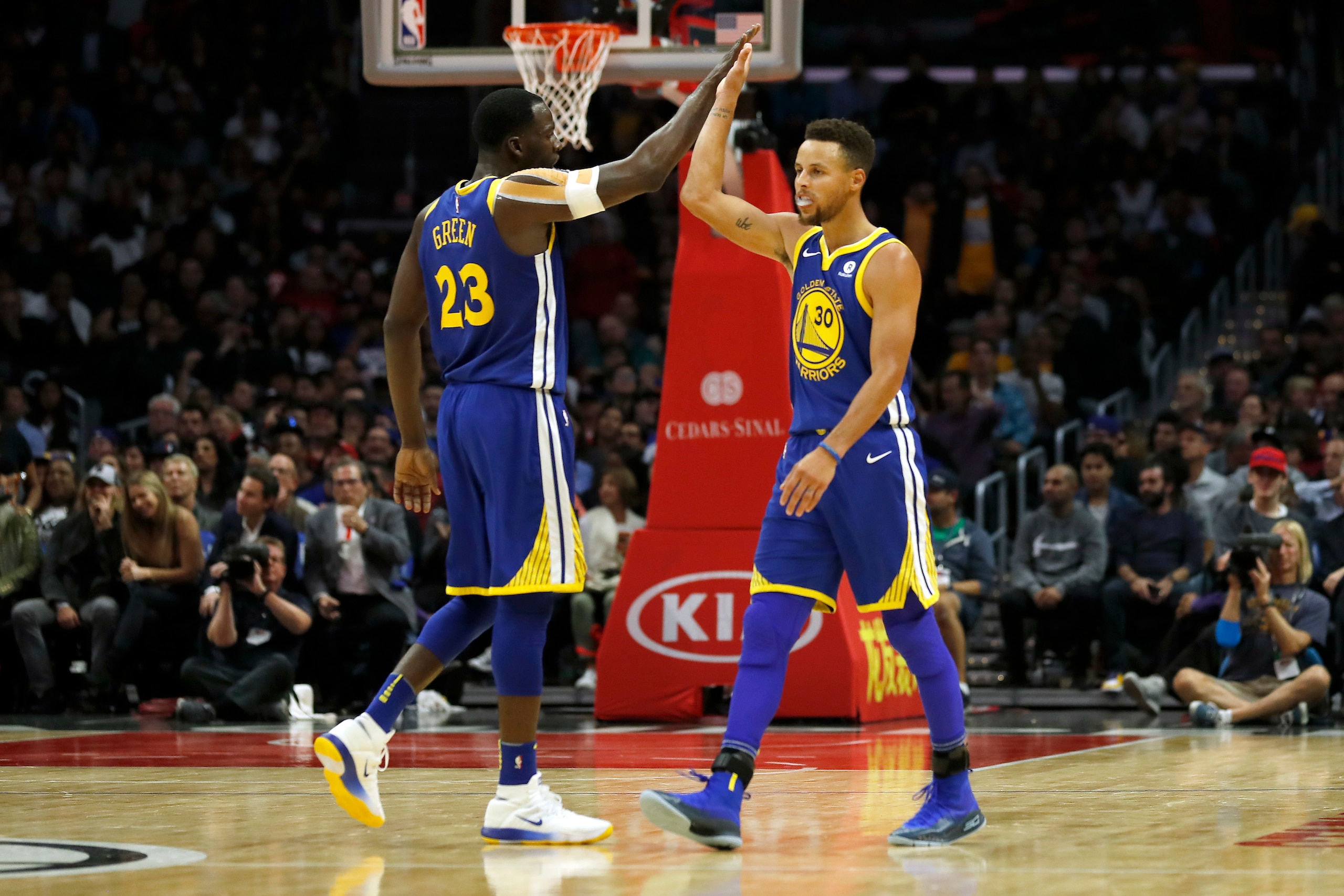 Golden State Warriors forward Draymond Green, left, high-fives guard Stephen Curry, right, during the first half of an NBA basketball game against the Los Angeles Clippers, Monday, Oct. 30, 2017, in Los Angeles. (AP Photo/Ryan Kang)