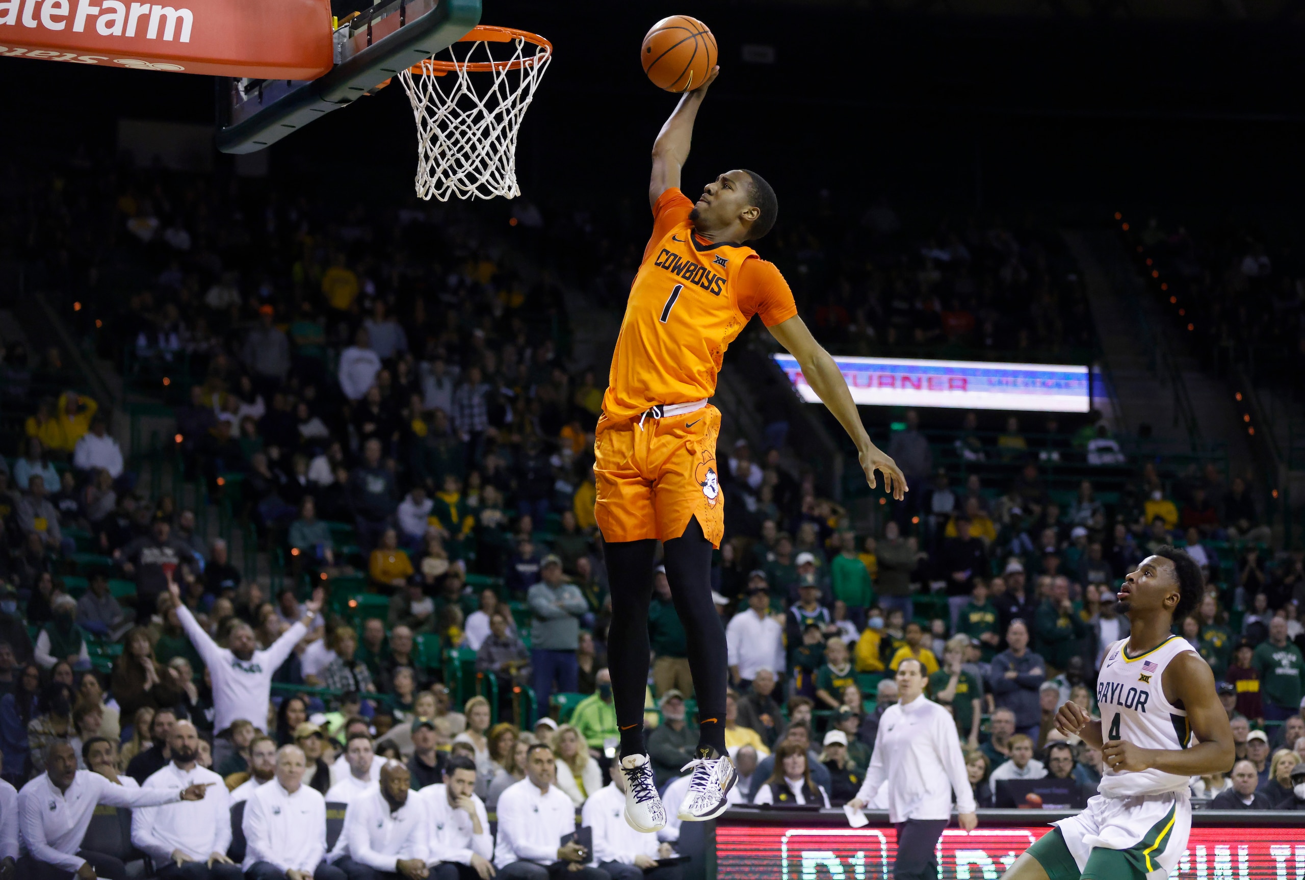 WACO, TX - JANUARY 15: Bryce Thompson #1 of the Oklahoma State Cowboys goes up for a break away slam dunk as LJ Cryer #4 of the Baylor Bears looks on in the first half at the Ferrell Center on January 15, 2022 in Waco, Texas. (Photo by Ron Jenkins/Getty Images)