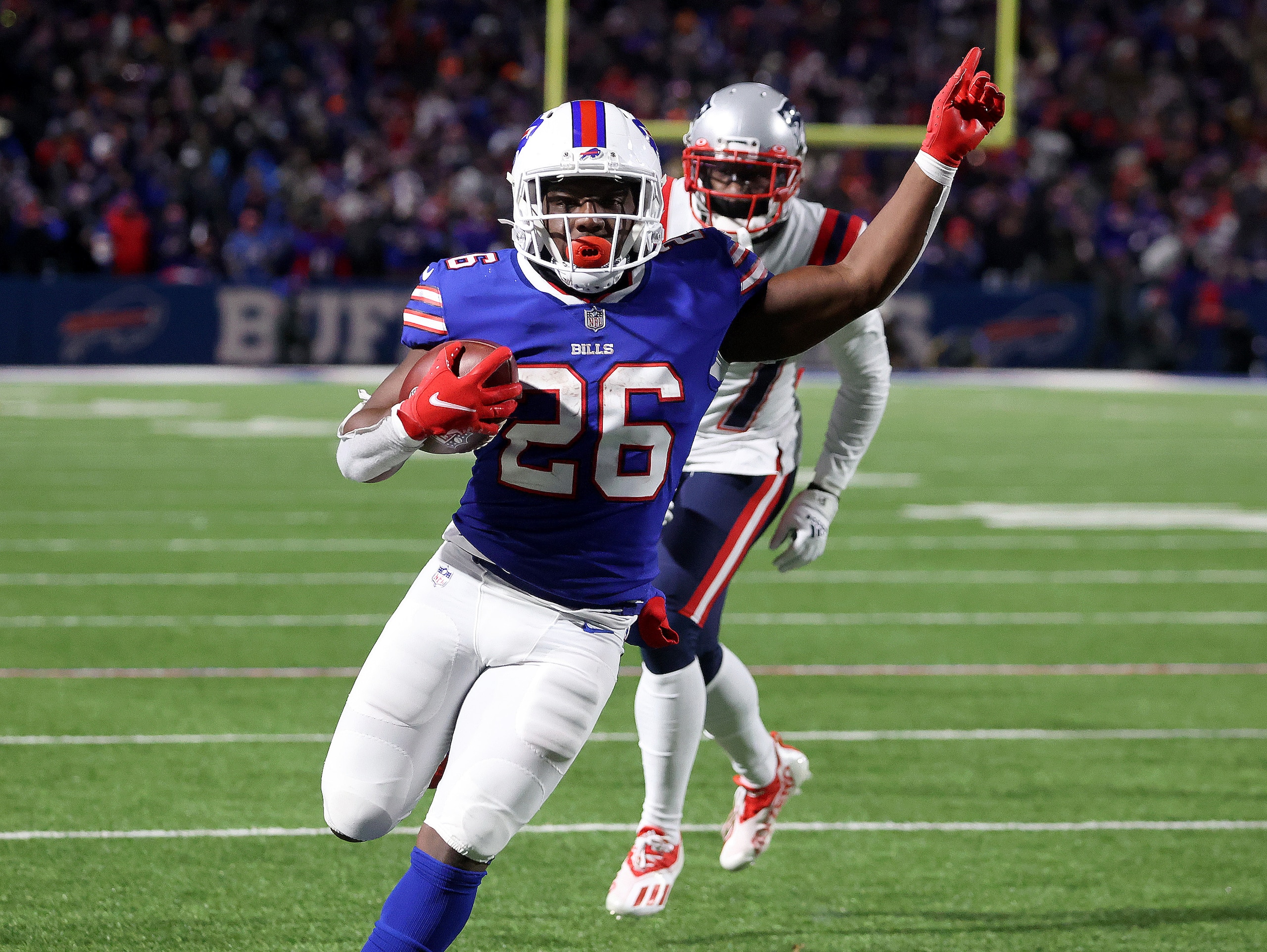 Orchard Park, NY - January 15: Buffalo Bills running back Devin Singletary (26) is untouched by New England Patriots cornerback J.C. Jackson (27) as he enters the end zone with his second touchdown of the game. The Buffalo Bills host the New England Patriots in a AFC wild-card game Saturday night January 15, 2022 at Highmark Stadium in Orchard Park, NY. (Photo by Barry Chin/The Boston Globe via Getty Images) Orchard Park, NY - January 15: Buffalo Bills running back Devin Singletary (26) is untouched by New England Patriots cornerback J.C. Jackson (27) as he enters the end zone with his second touchdown of the game. The Buffalo Bills host the New England Patriots in a AFC wild-card game Saturday night January 15, 2022 at Highmark Stadium in Orchard Park, NY. (Photo by Barry Chin/The Boston Globe via Getty Images)