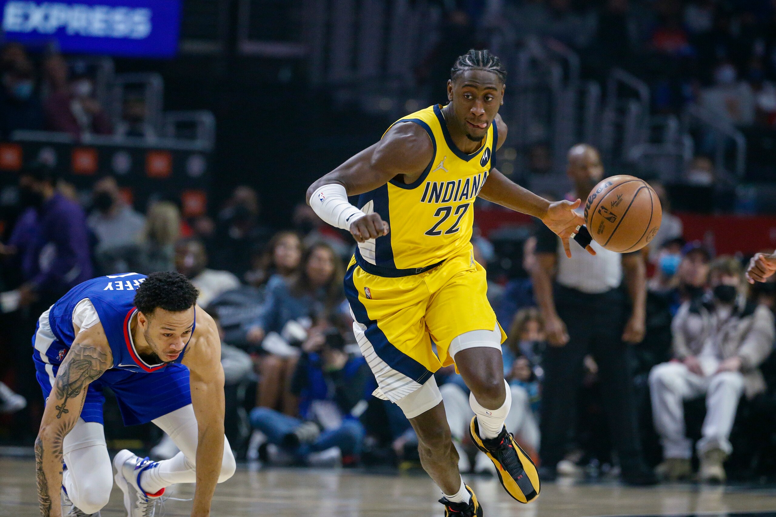 Indiana Pacers guard Caris LeVert (22) dribbles the ball away from Los Angeles Clippers guard Amir Coffey (7) during the first half of an NBA basketball game in Los Angeles, Monday, Jan. 17, 2022. (AP Photo/Ringo H.W. Chiu)