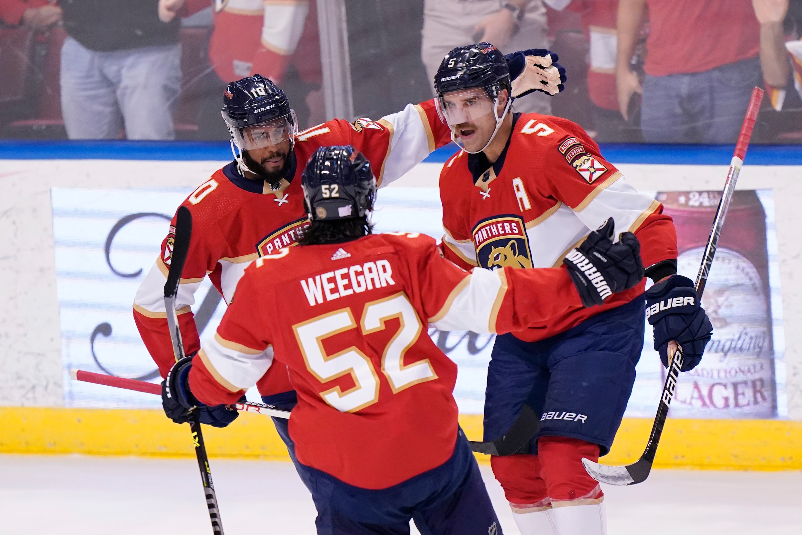 Florida Panthers defenseman MacKenzie Weegar (52) and left wing Anthony Duclair (10) congratulate defenseman Aaron Ekblad (5) after Ekblad scored a goal during the first period of an NHL hockey game against the Washington Capitals, Thursday, Nov. 4, 2021, in Sunrise, Fla. (AP Photo/Wilfredo Lee)