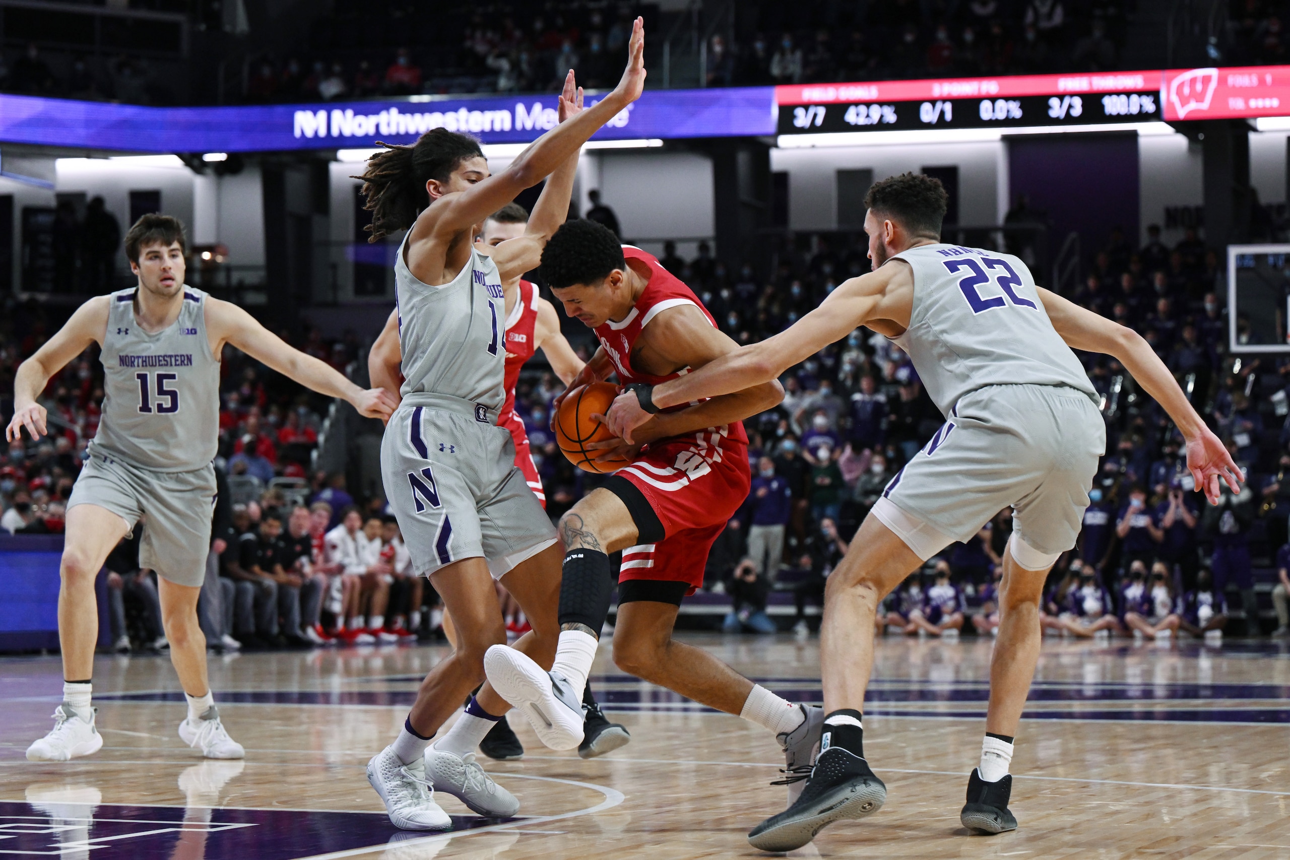 EVANSTON, ILLINOIS - JANUARY 18: Johnny Davis #1 of the Wisconsin Badgers is fouled driving against Pete Nance #22 of the Northwestern Wildcats in the first half at Welsh-Ryan Arena on January 18, 2022 in Evanston, Illinois. (Photo by Quinn Harris/Getty Images)