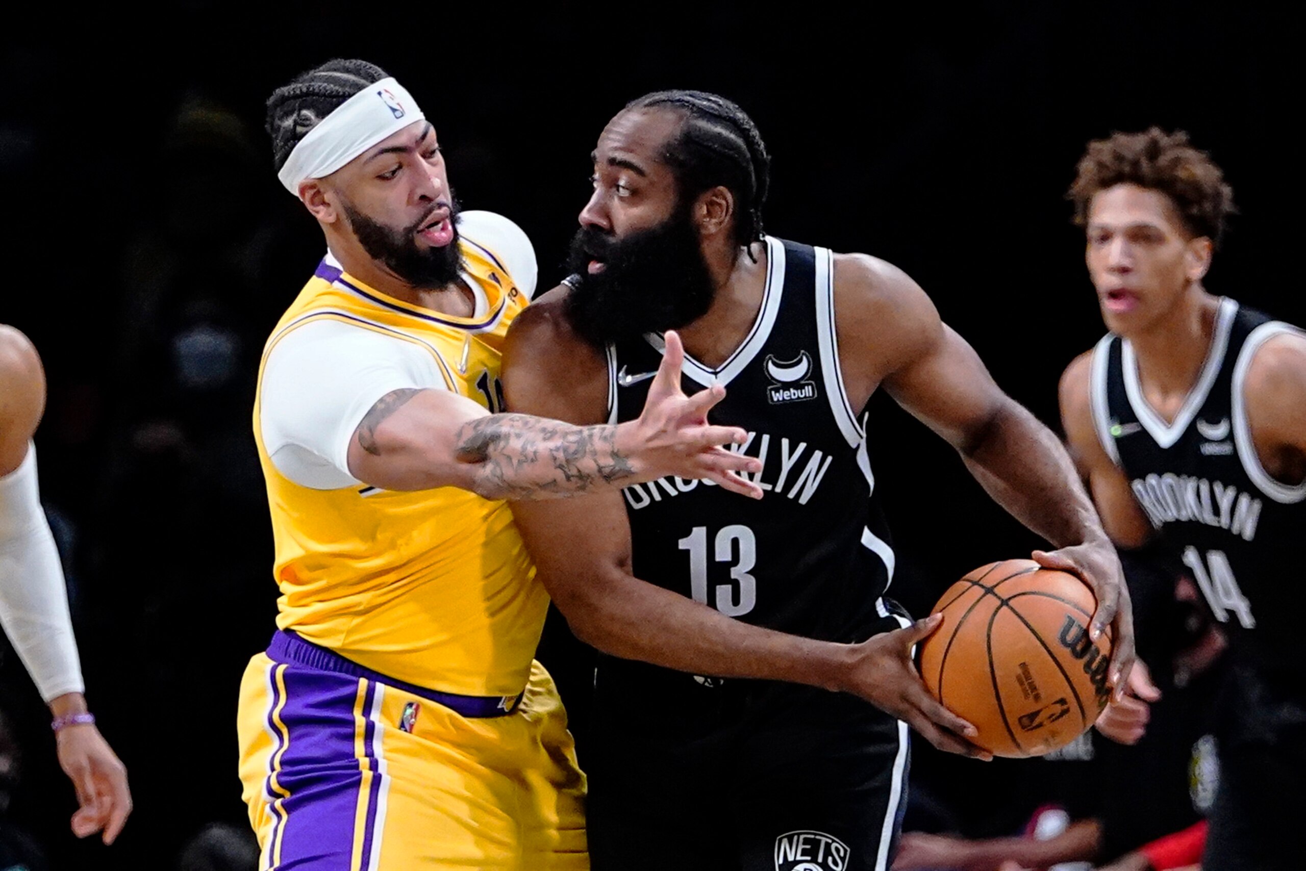 Los Angeles Lakers' Anthony Davis, left, defends Brooklyn Nets' James Harden during the first half of an NBA basketball game Tuesday, Jan. 25, 2022 in New York. (AP Photo/Frank Franklin II)