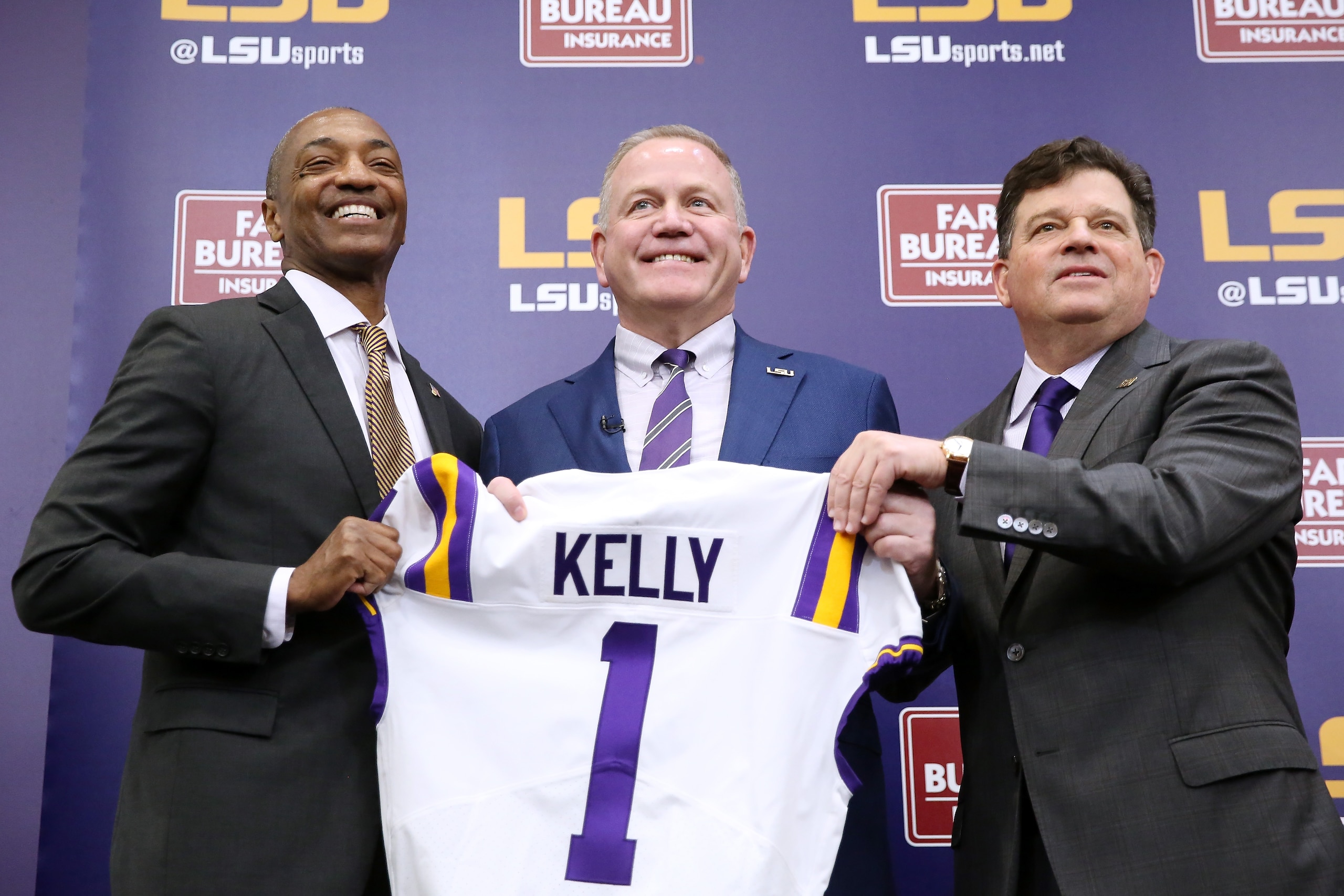 BATON ROUGE, LOUISIANA - DECEMBER 01: Brian Kelly (C) is introduced as the head football coach of the LSU Tigers by LSU President William F. Tate IV (L) and athletics director Scott Woodward during a news conference at Tiger Stadium on December 01, 2021 in Baton Rouge, Louisiana. (Photo by Jonathan Bachman/Getty Images)