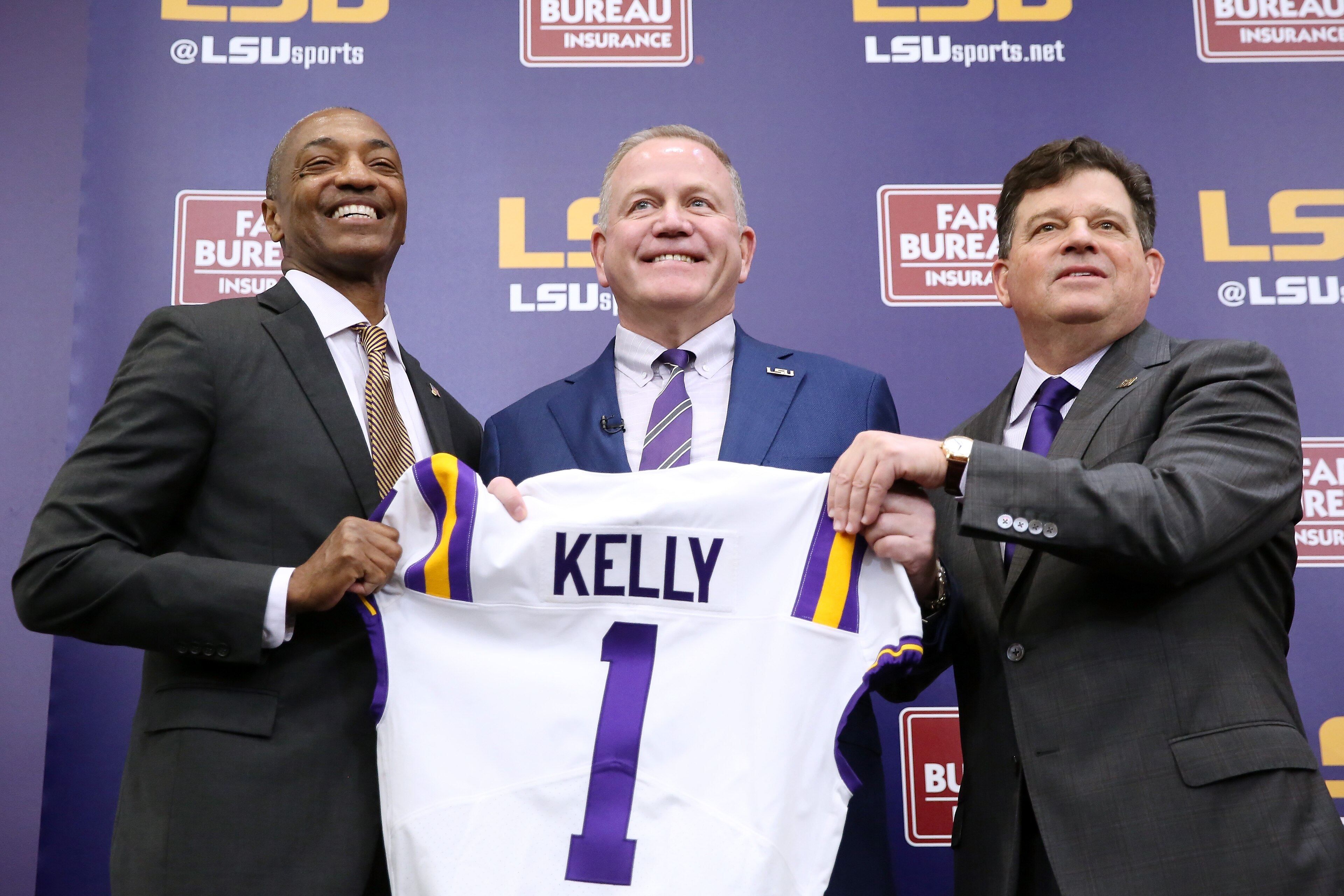 BATON ROUGE, LOUISIANA - DECEMBER 01: Brian Kelly (C) is introduced as the head football coach of the LSU Tigers by LSU President William F. Tate IV (L) and athletics director Scott Woodward during a news conference at Tiger Stadium on December 01, 2021 in Baton Rouge, Louisiana. (Photo by Jonathan Bachman/Getty Images)