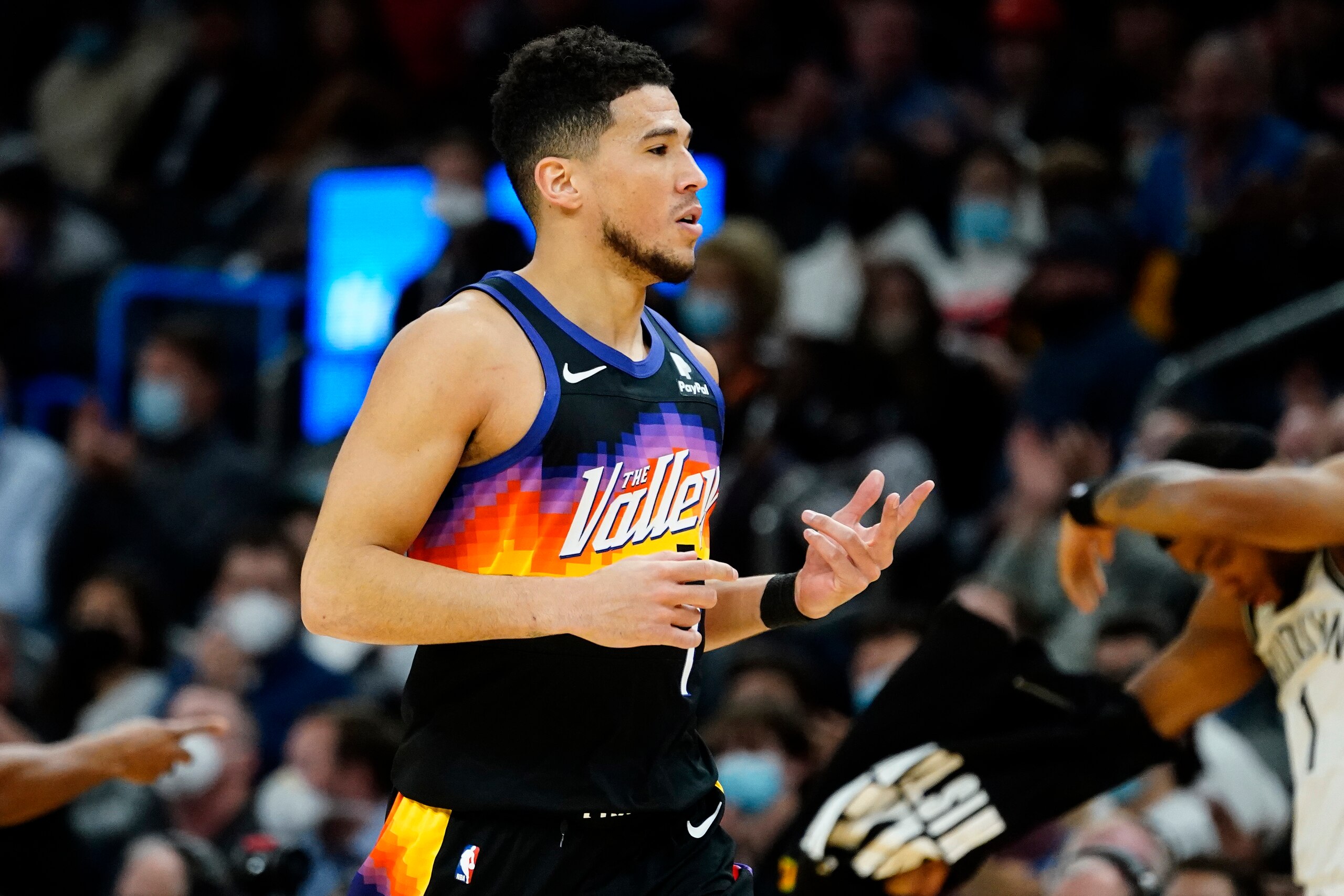 Phoenix Suns guard Devin Booker (1) motions to the Brooklyn Nets bench after making a three pointer during the first half of an NBA basketball game, Tuesday, Feb. 1, 2022, in Phoenix. (AP Photo/Matt York)