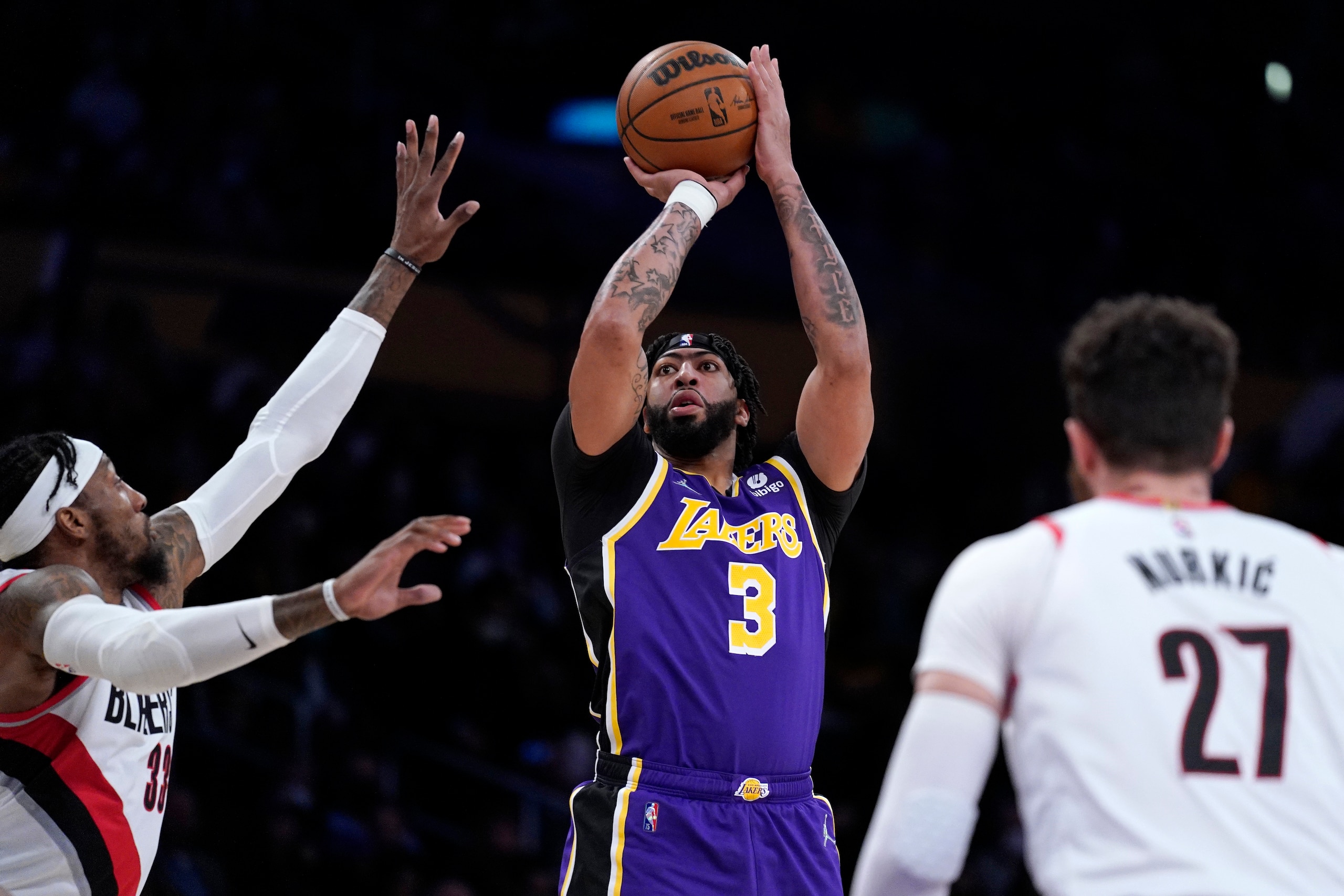 Los Angeles Lakers forward Anthony Davis, center, shoots as Portland Trail Blazers forward Robert Covington, left, and center Jusuf Nurkic defend during the first half of an NBA basketball game Wednesday, Feb. 2, 2022, in Los Angeles. (AP Photo/Mark J. Terrill)