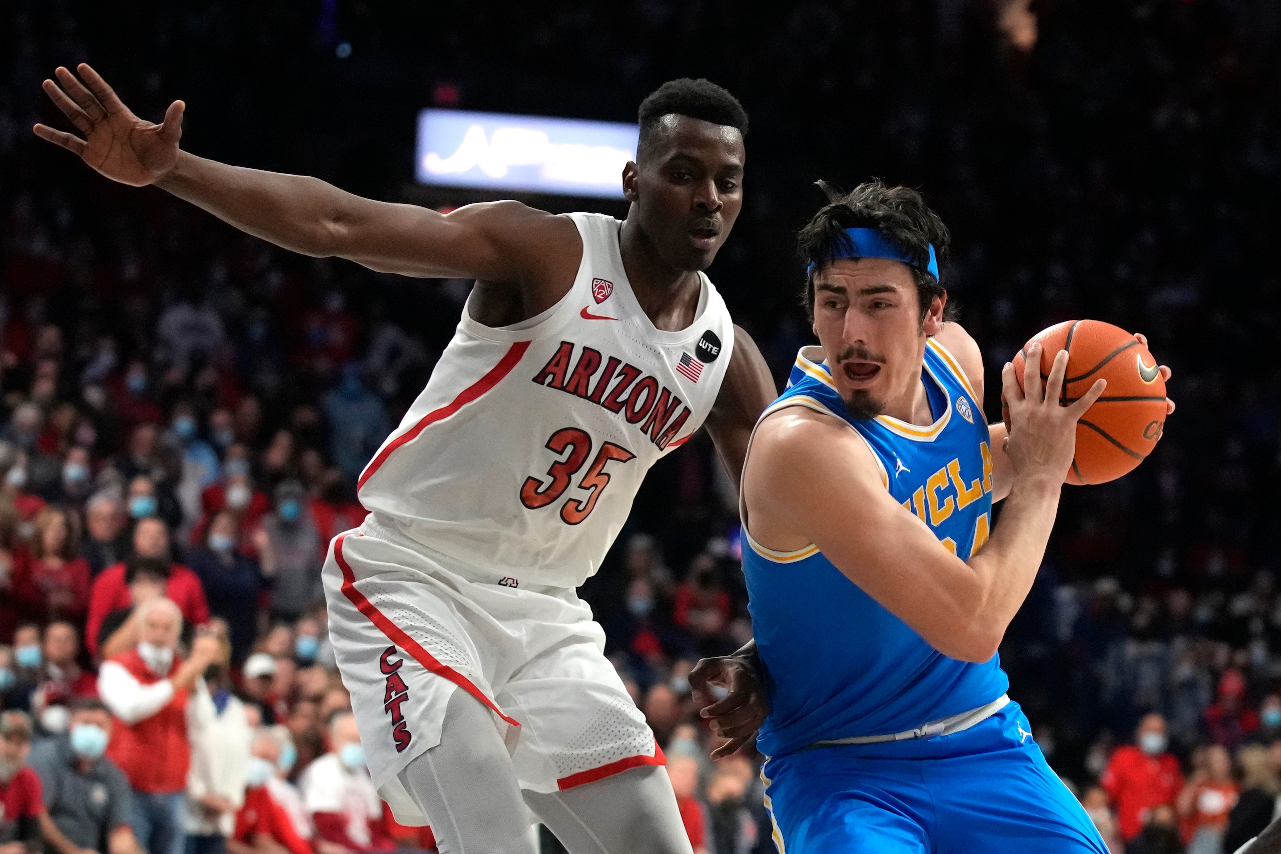 UCLA guard Jaime Jaquez Jr. drives past Arizona center Christian Koloko (35) during the first half of an NCAA college basketball game Thursday, Feb. 3, 2022, in Tucson, Ariz. (AP Photo/Rick Scuteri)