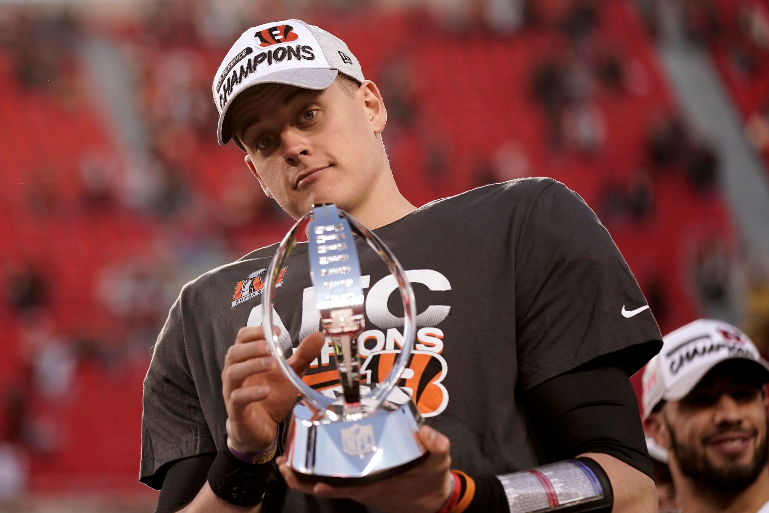 Cincinnati Bengals quarterback Joe Burrow (9) holds the Lamar Hunt trophy after an AFC championship NFL football game against the Kansas City Chiefs, Sunday, Jan. 30, 2022, in Kansas City, Mo. The Bengals won 27-24 in overtime. (AP Photo/Charlie Riedel)