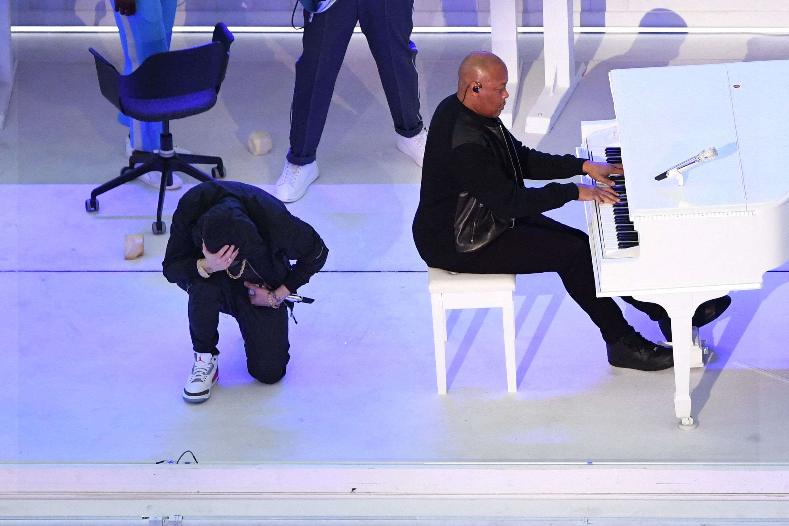 US rapper Eminem kneels on stage as he performs with US rapper Dr. Dre during the halftime show of Super Bowl LVI between the Los Angeles Rams and the Cincinnati Bengals at SoFi Stadium in Inglewood, California, on February 13, 2022. (Photo by VALERIE MACON / AFP) (Photo by VALERIE MACON/AFP via Getty Images)