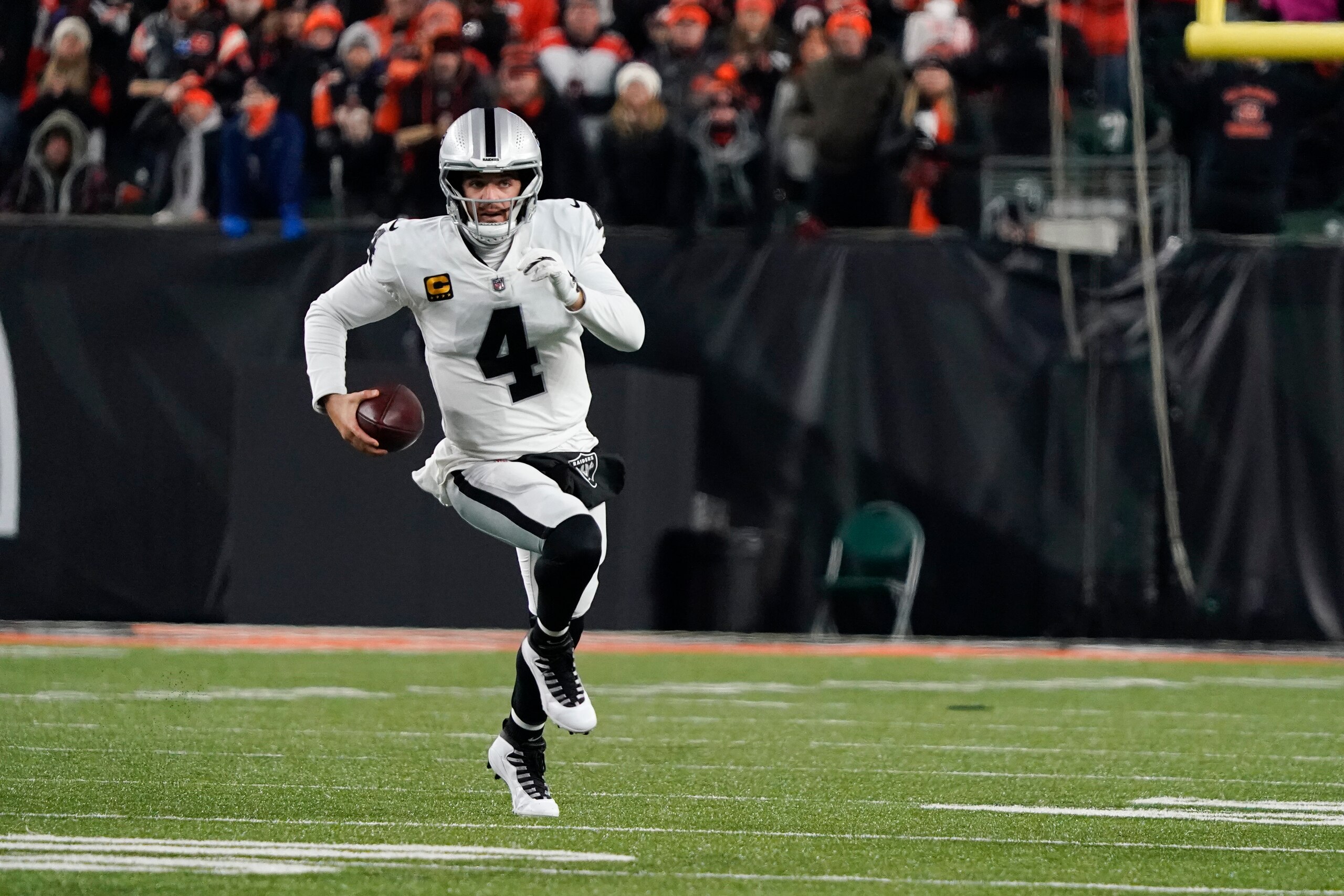 Las Vegas Raiders quarterback Derek Carr runs during the first half of an NFL wild-card playoff football game against the Cincinnati Bengals, Saturday, Jan. 15, 2022, in Cincinnati. (AP Photo/Jeff Dean)