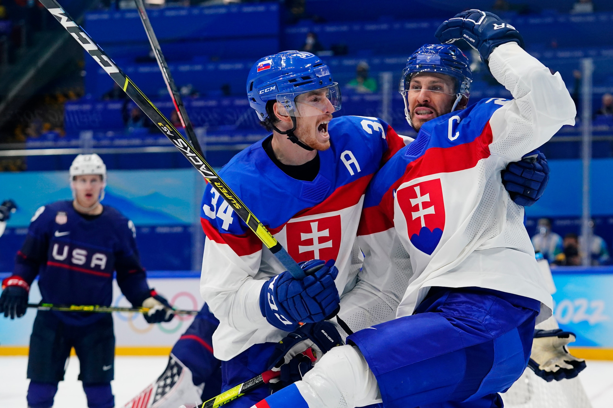 Slovakia's Marek Hrivikl, right, is hugged by Peter Cehlarik (34) after Hrivikl scored a goal against the United States during a men's quarterfinal hockey game at the 2022 Winter Olympics, Wednesday, Feb. 16, 2022, in Beijing. (AP Photo/Matt Slocum)