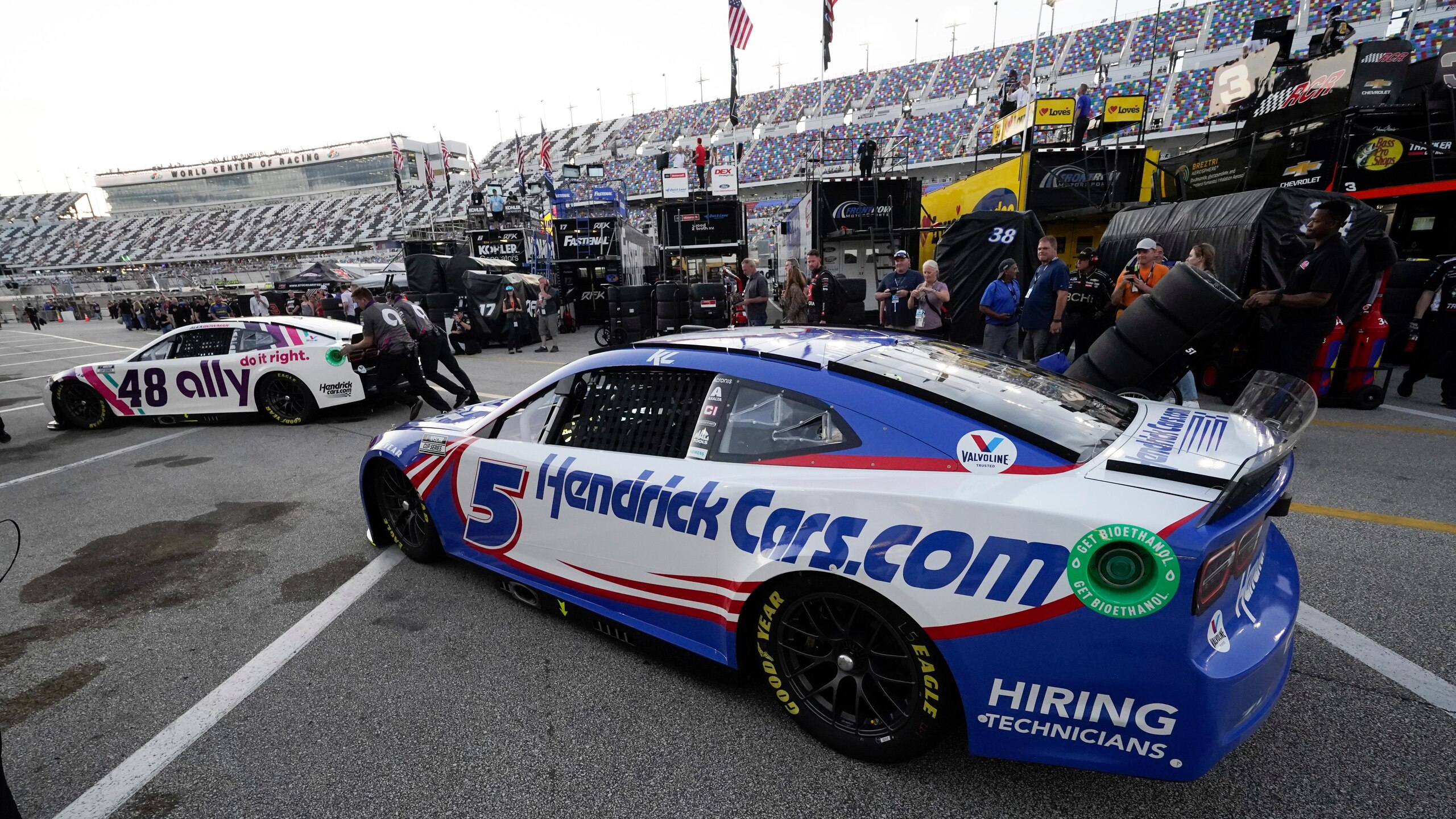 Alex Bowman (48) gets a push from crew members while leaving his garage as Kyle Larson (5) waits his turn during NASCAR Daytona 500 auto race practice at Daytona International Speedway, Friday, Feb. 18, 2022, in Daytona Beach, Fla. (AP Photo/John Raoux)