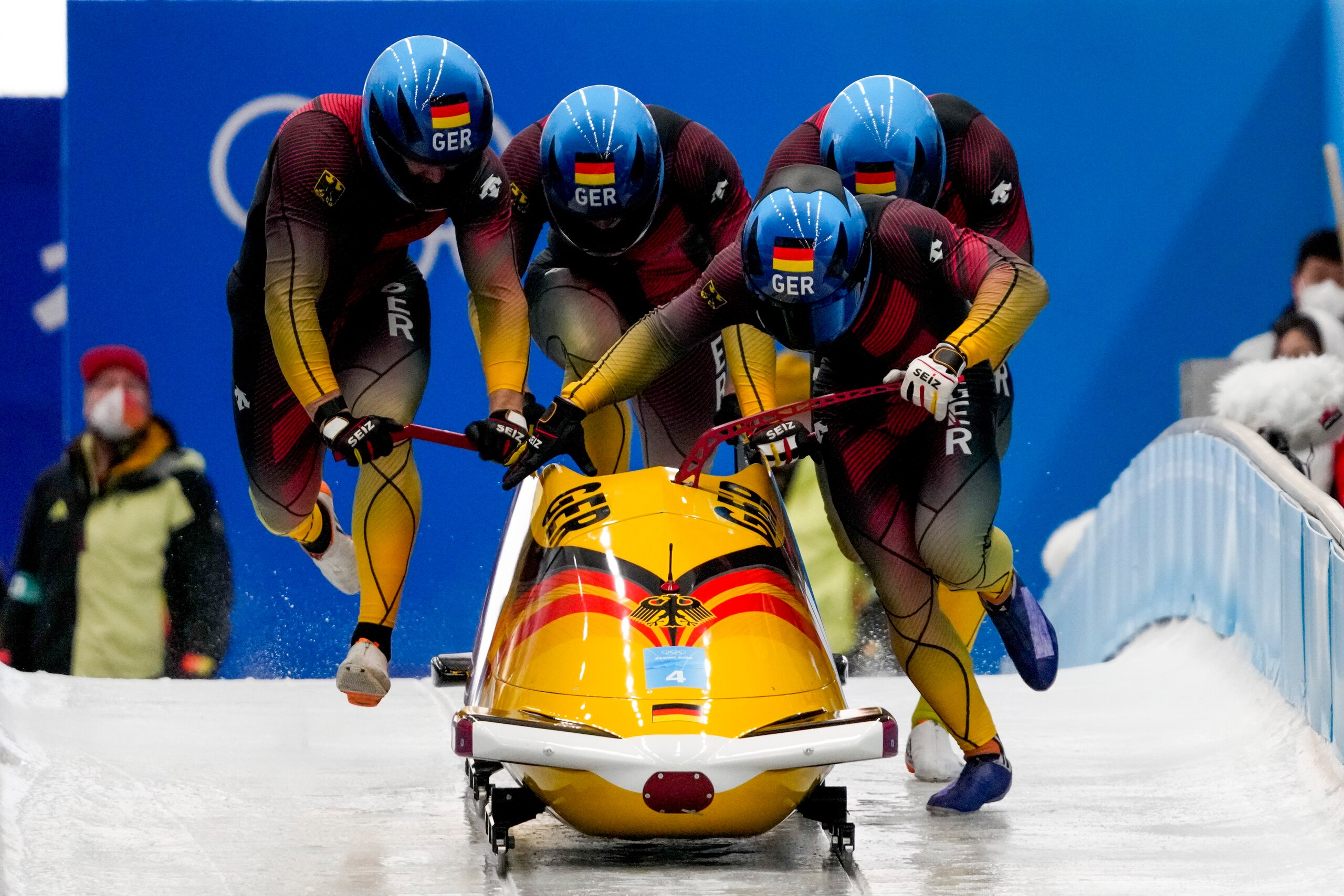 Francesco Friedrich, Thorsten Margis, Candy Bauer and Alexander Schueller, of Germany, start the 4-man heat 3 at the 2022 Winter Olympics, Sunday, Feb. 20, 2022, in the Yanqing district of Beijing. (AP Photo/Pavel Golovkin)