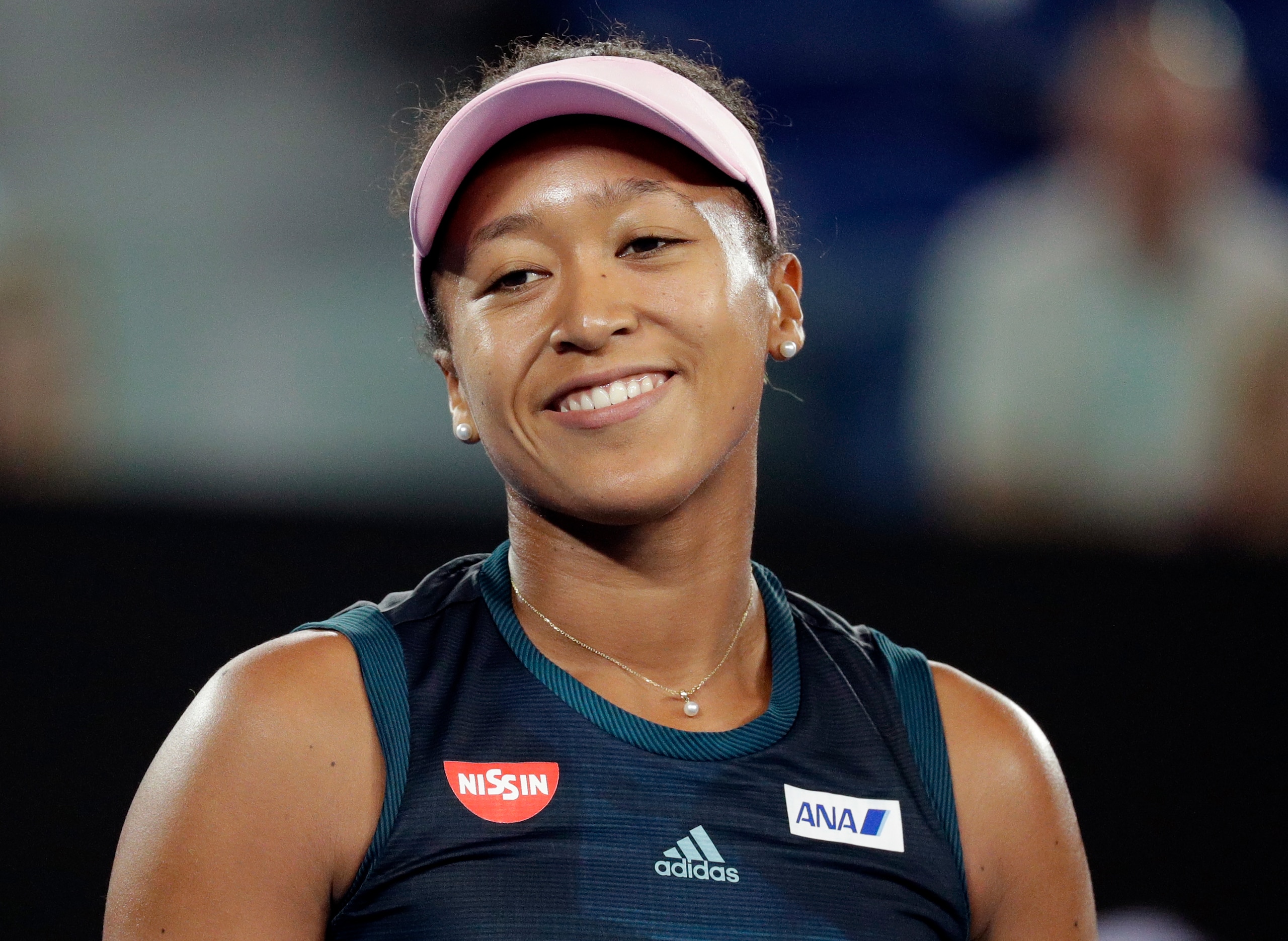 Japan's Naomi Osaka smiles during her first round match against Poland's Magda Linette at the Australian Open tennis championships in Melbourne, Australia, Tuesday, Jan. 15, 2019. (AP Photo/Kin Cheung)