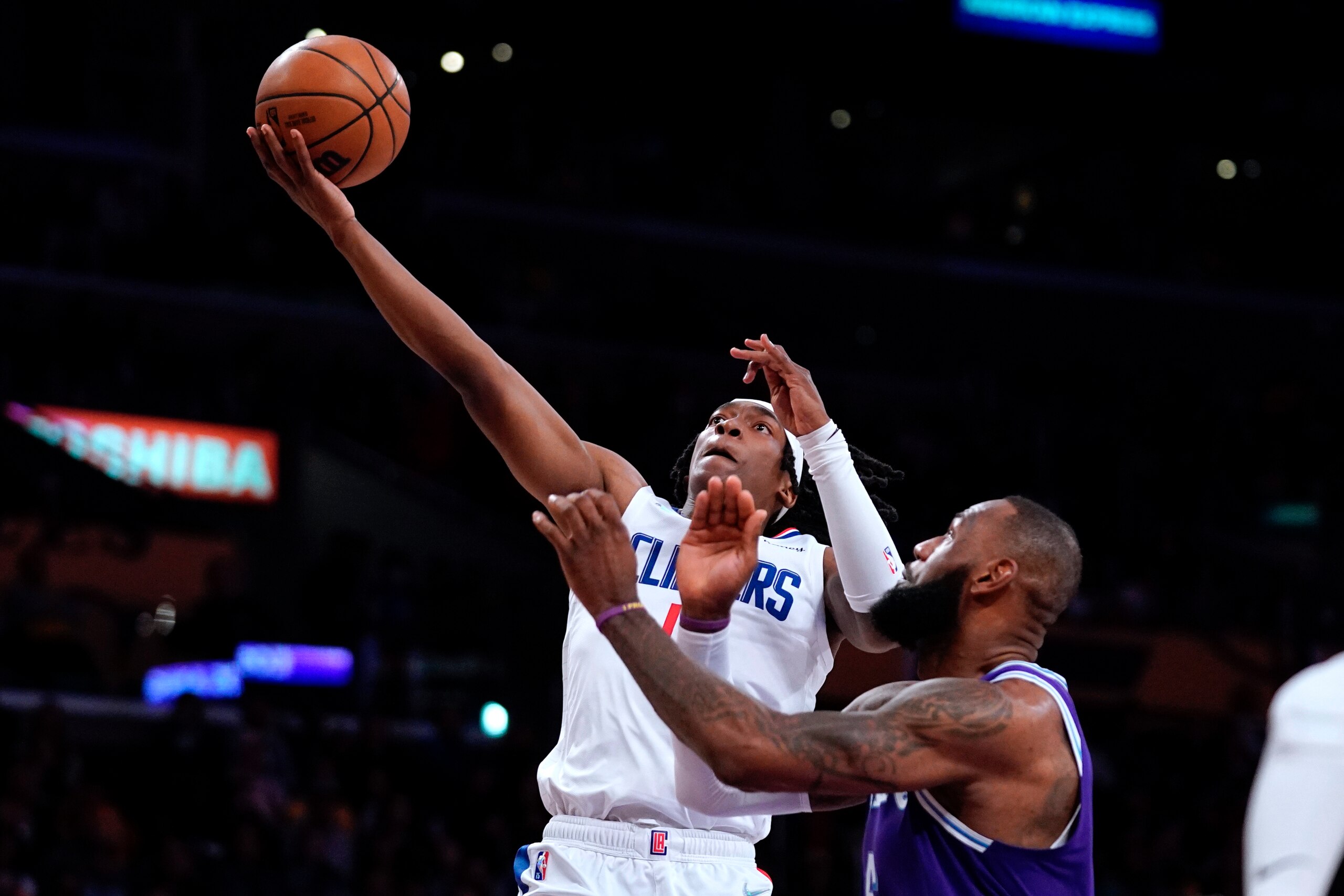 Los Angeles Clippers guard Terance Mann, left, shoots as Los Angeles Lakers' Lebron James defends during the first half of an NBA basketball game Friday, Feb. 25, 2022, in Los Angeles. (AP Photo/Mark J. Terrill)