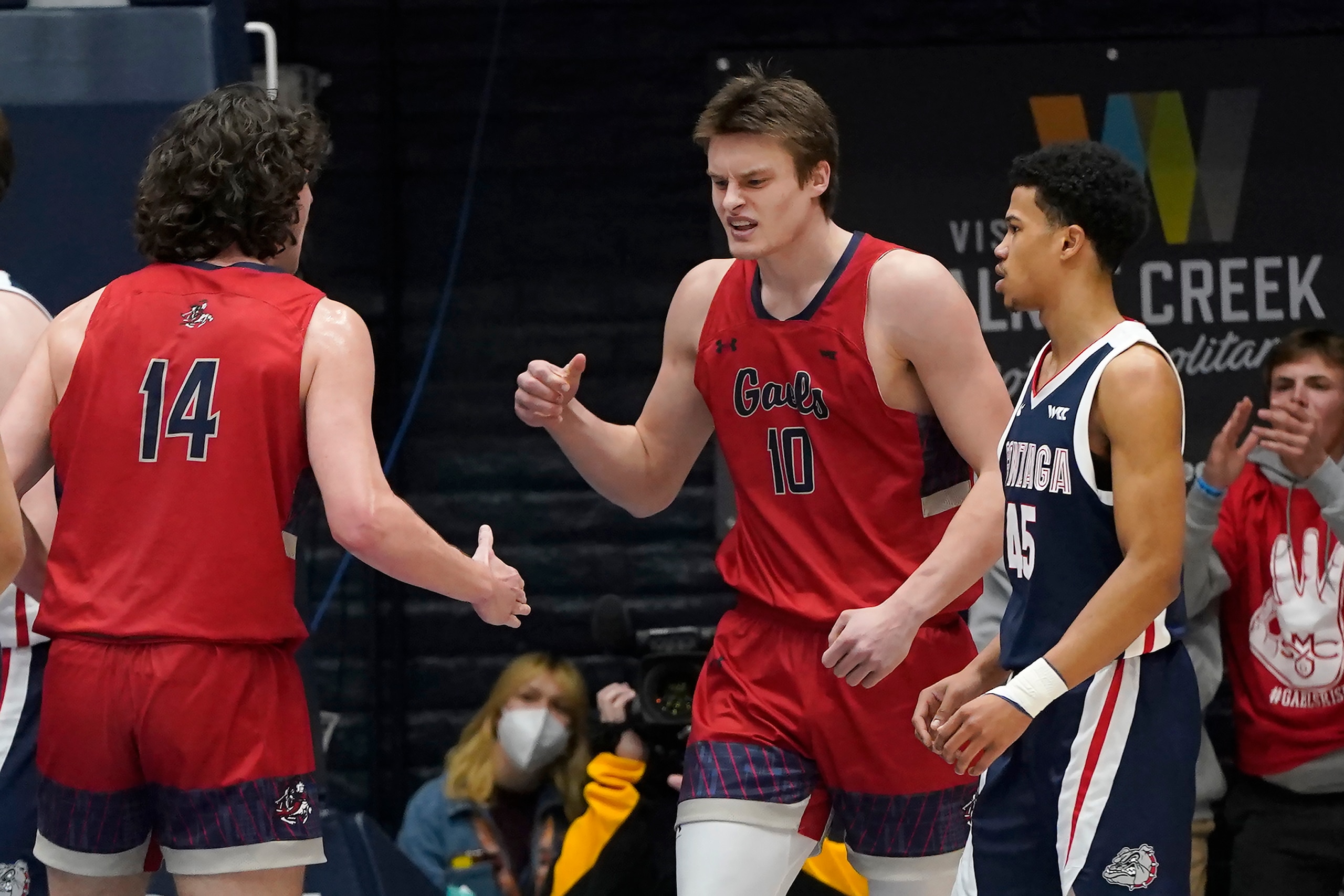 Saint Mary's center Mitchell Saxen (10) celebrates with forward Kyle Bowen (14) after scoring next to Gonzaga guard Rasir Bolton during the first half of an NCAA college basketball game in Moraga, Calif., Saturday, Feb. 26, 2022. (AP Photo/Jeff Chiu)