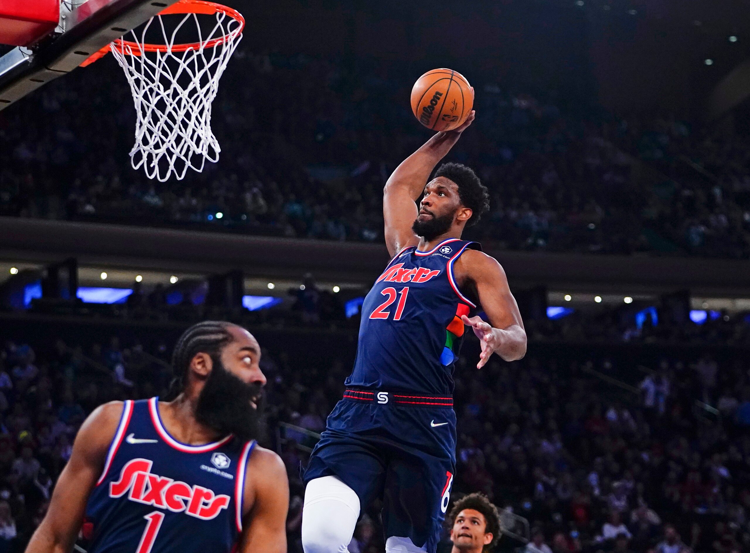 New York Knicks' Cam Reddish (21) dunks the ball in front of New York Knicks' Evan Fournier (13) after a pass from James Harden (1) during the first half of an NBA basketball game Sunday, Feb. 27, 2022, in New York. (AP Photo/Frank Franklin II)