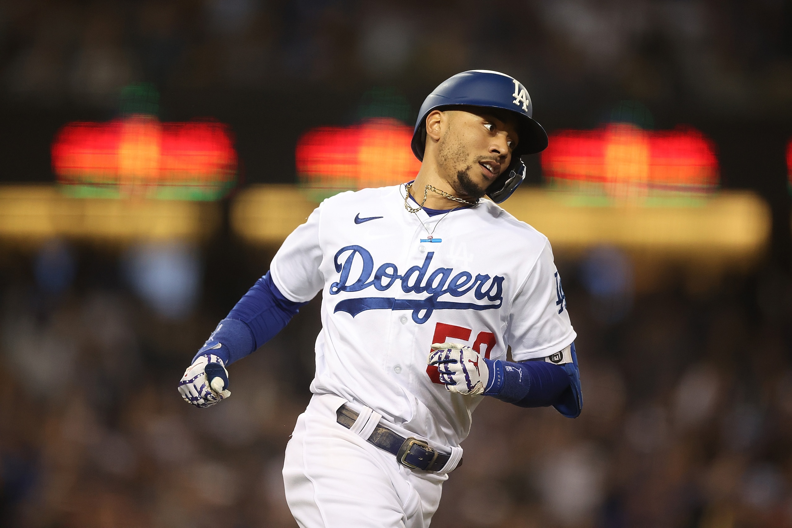 LOS ANGELES, CALIFORNIA - OCTOBER 21: Mookie Betts #50 of the Los Angeles Dodgers runs to first base following a base hit during the eighth inning of Game Five of the National League Championship Series against the Atlanta Braves at Dodger Stadium on October 21, 2021 in Los Angeles, California. (Photo by Ronald Martinez/Getty Images)