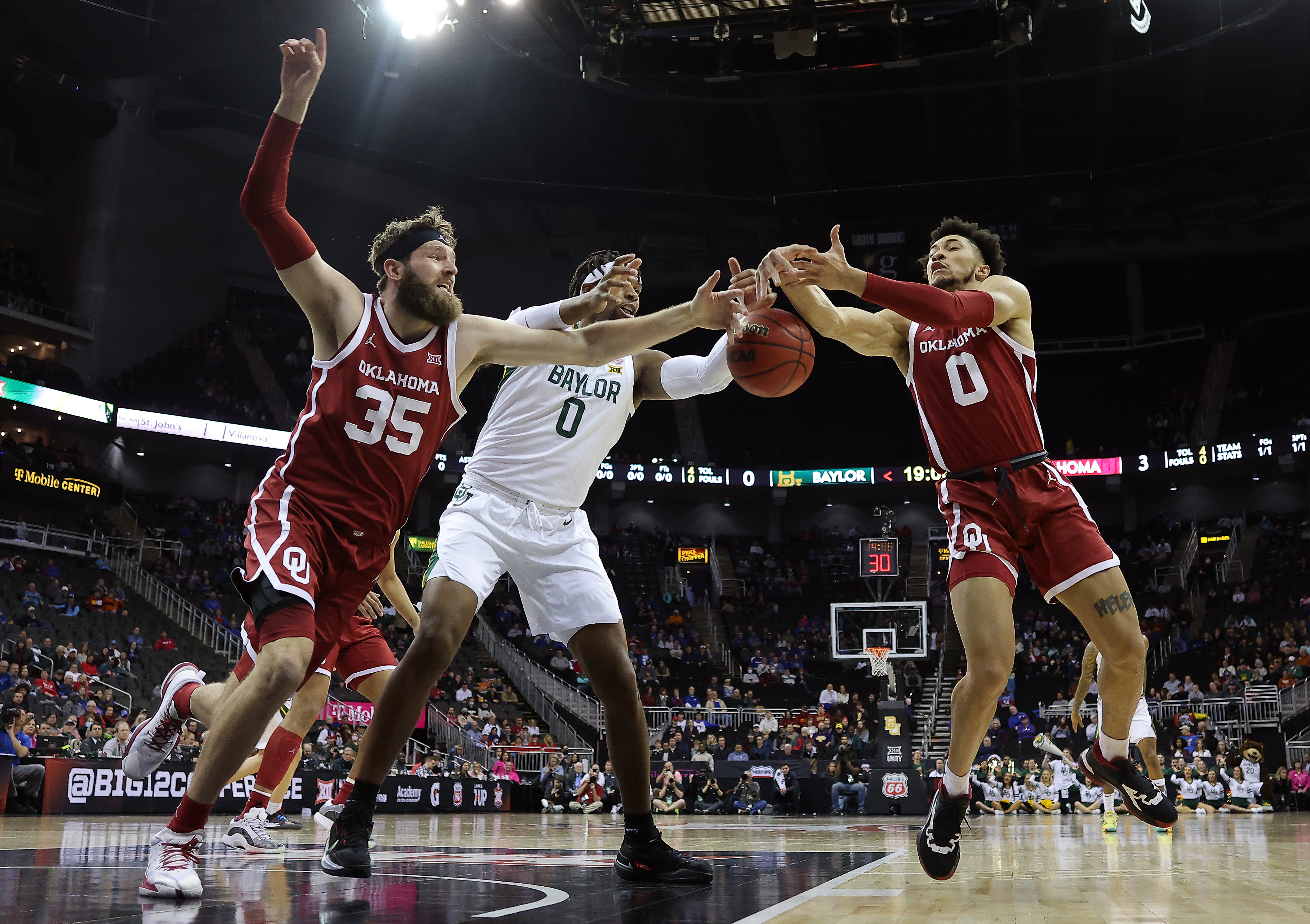KANSAS CITY, MISSOURI - MARCH 10:  Flo Thamba #0 of the Baylor Bears competes with Tanner Groves #35 and Jordan Goldwire #0 of the Oklahoma Sooners for a loose ball during the first round game of the 2022 Phillips 66 Big 12 Men's Basketball Championship at T-Mobile Center on March 10, 2022 in Kansas City, Missouri. (Photo by Jamie Squire/Getty Images)