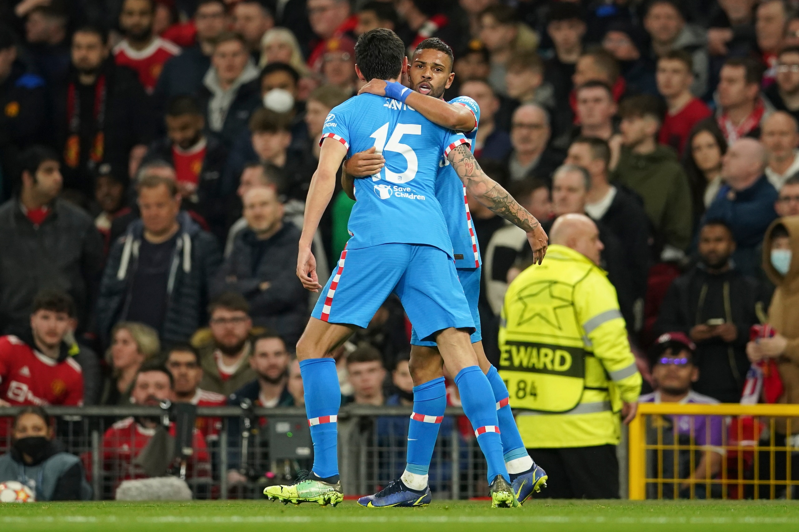 Atletico Madrid's Renan Lodi is congratulated by teammate Stefan Savic, left, after scoring his team's first goal during the Champions League round of 16, second leg soccer match between Manchester United and Atletico Madrid at Old Trafford, Manchester, England, Tuesday, March 15, 2022. (AP Photo/Dave Thompson)