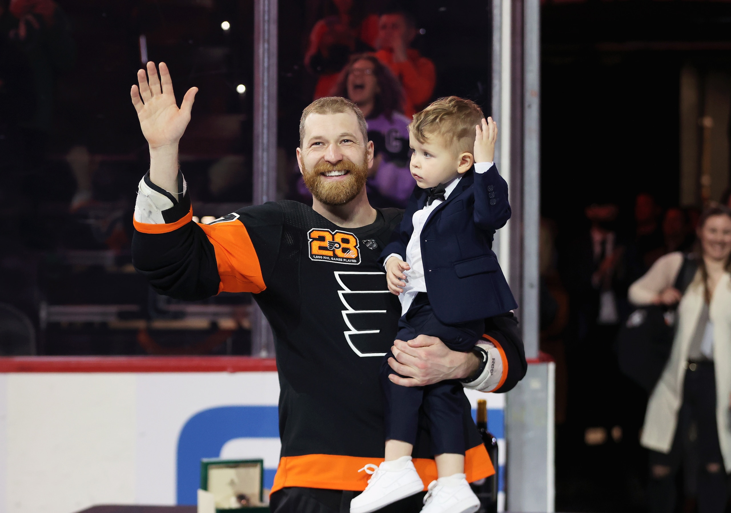 PHILADELPHIA, PA - MARCH 17:  Claude Giroux #28 of the Philadelphia Flyers acknowledges the crowd with his son Gavin during a pregame ceremony honoring Giroux's 1,000th NHL game as a member of the Flyers prior to his game against the Nashville Predators at the Wells Fargo Center on March 17, 2022 in Philadelphia, Pennsylvania.  (Photo by Len Redkoles/NHLI via Getty Images)