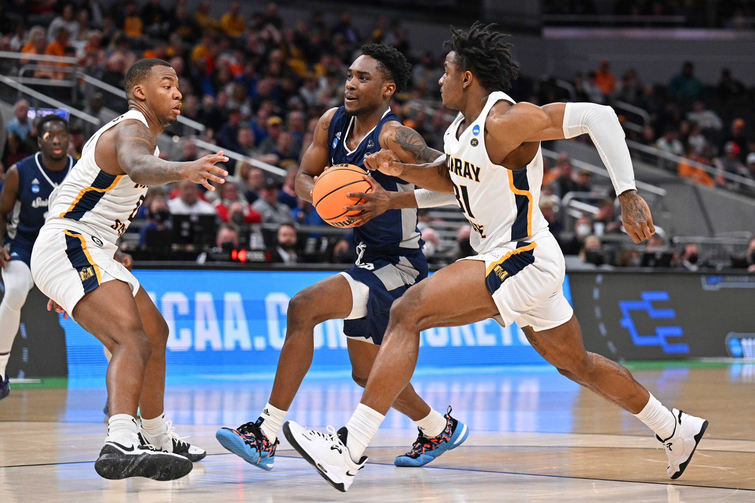 INDIANAPOLIS, IN - MARCH 19: KC Ndefo #11 of the St. Peter's Peacocks, center, takes the ball to the basket while being defended by KJ Williams #0, left, and Jordan Skipper-Brown #31 of the Murray State Racers during the first half of action in the second round of the 2022 NCAA Men's Basketball Tournament held at Gainbridge Fieldhouse on March 19, 2022 in Indianapolis, Indiana. Michigan won 76-68. (Photo by Jamie Sabau/NCAA Photos via Getty Images) INDIANAPOLIS, IN - MARCH 19: KC Ndefo #11 of the St. Peter's Peacocks, center, takes the ball to the basket while being defended by KJ Williams #0, left, and Jordan Skipper-Brown #31 of the Murray State Racers during the first half of action in the second round of the 2022 NCAA Men's Basketball Tournament held at Gainbridge Fieldhouse on March 19, 2022 in Indianapolis, Indiana. Michigan won 76-68. (Photo by Jamie Sabau/NCAA Photos via Getty Images)
