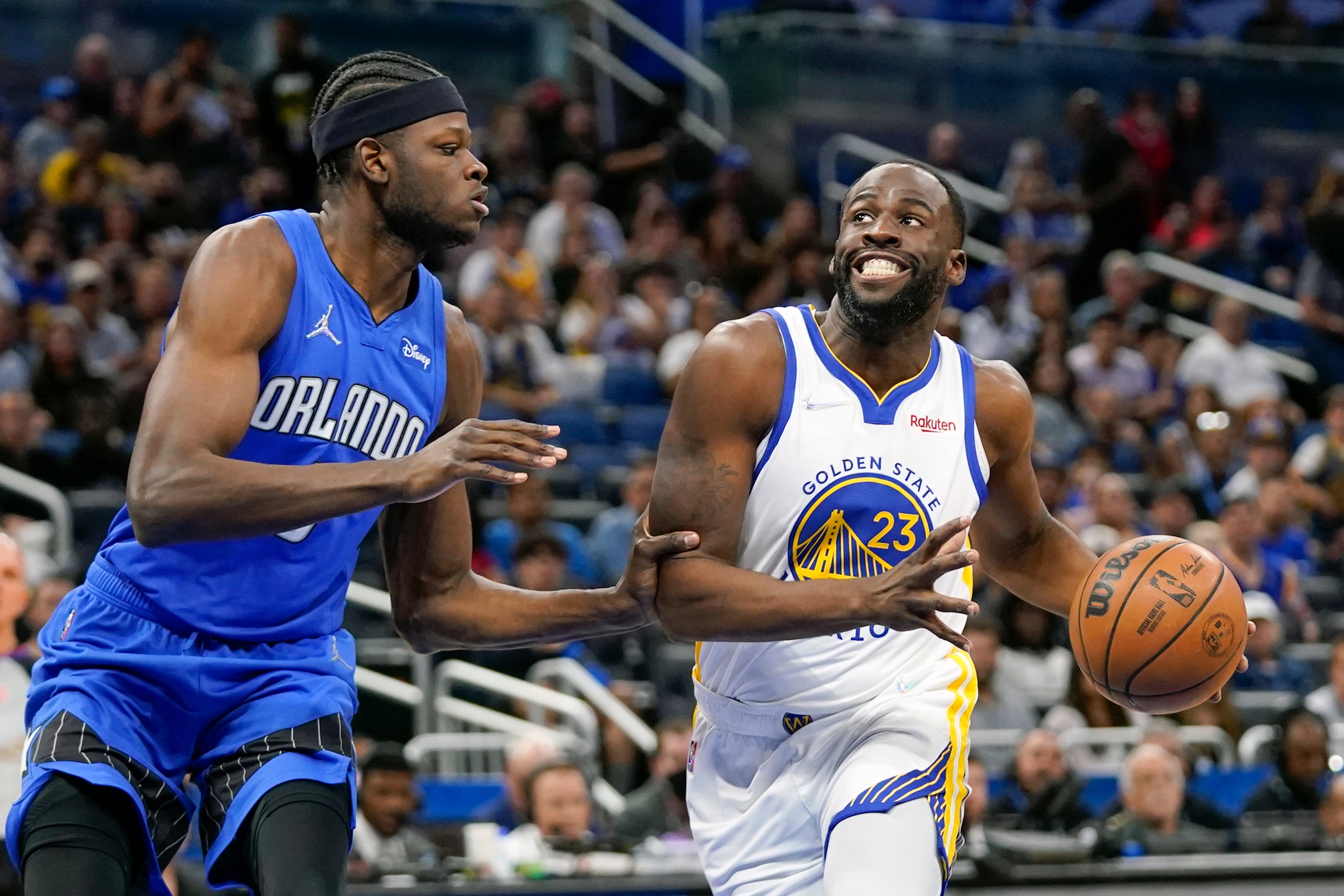 Golden State Warriors forward Draymond Green (23) goes to the basket against Orlando Magic center Mo Bamba, left, during the first half of an NBA basketball game, Tuesday, March 22, 2022, in Orlando, Fla. (AP Photo/John Raoux)